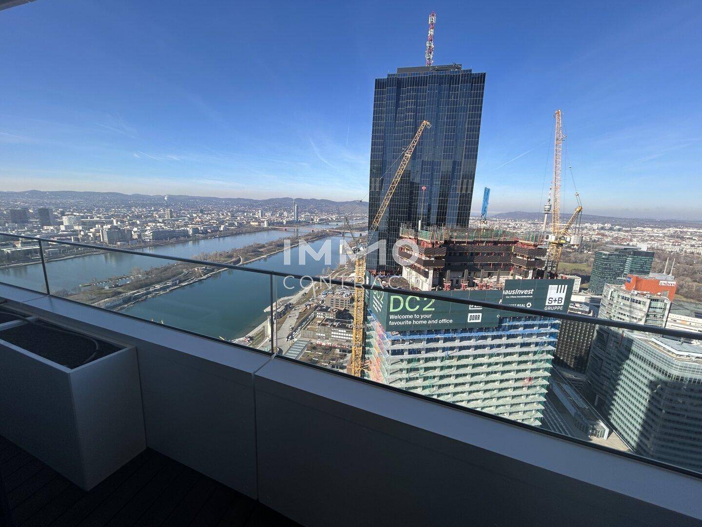 Balkon mit beeindruckendem Blick auf die moderne Skyline und den Fluss.