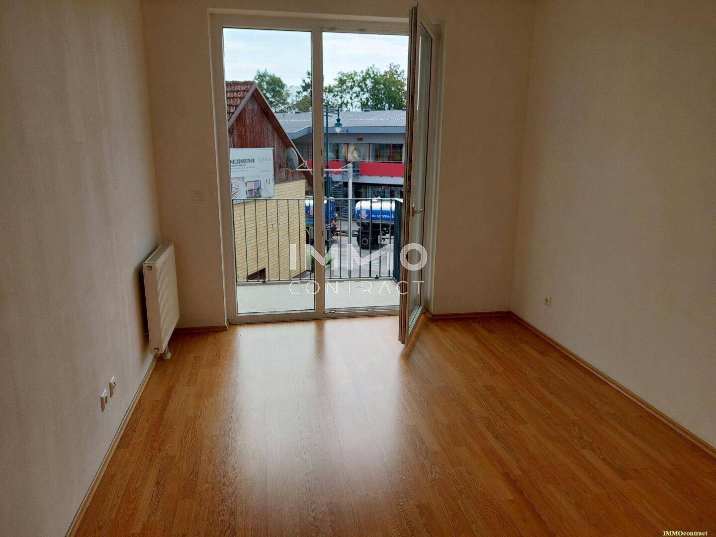 Helles Zimmer mit Holzboden und direktem Zugang zu einem französischen Balkon.