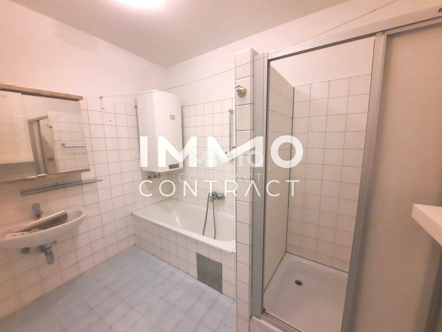 Badezimmer mit weißen Wandfliesen, Badewanne, Duschkabine und Waschbecken, funktional eingerichtet.