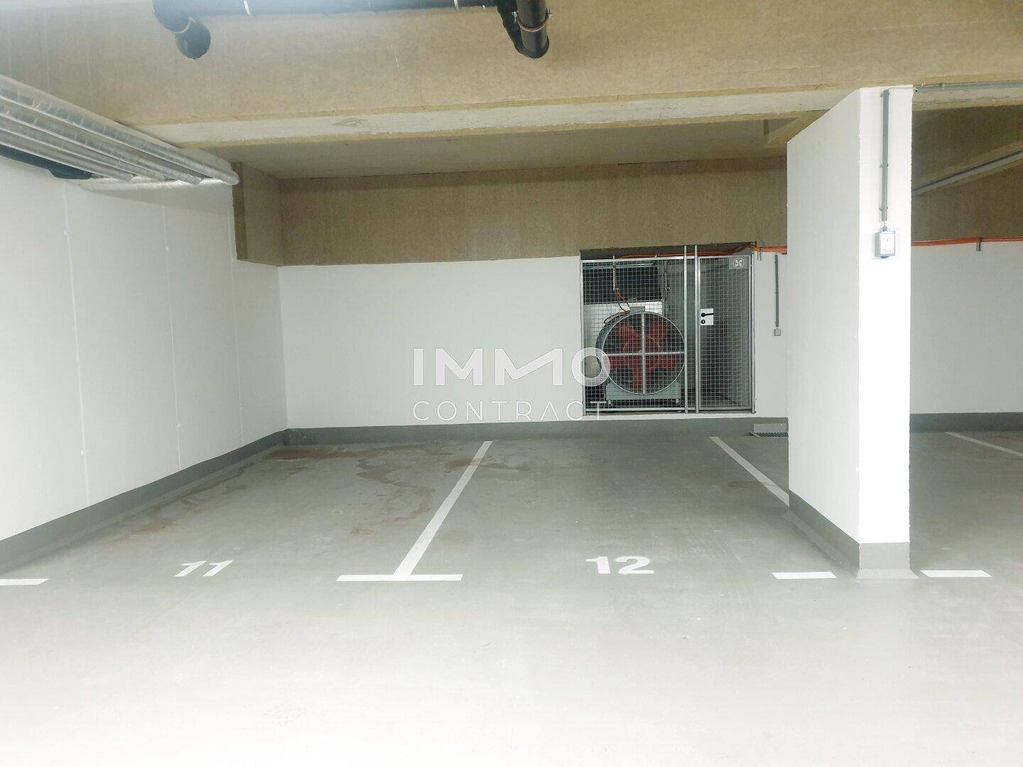 Weitere leere Stellplätze in der Tiefgarage mit sauberem Betonboden und guter Beleuchtung.