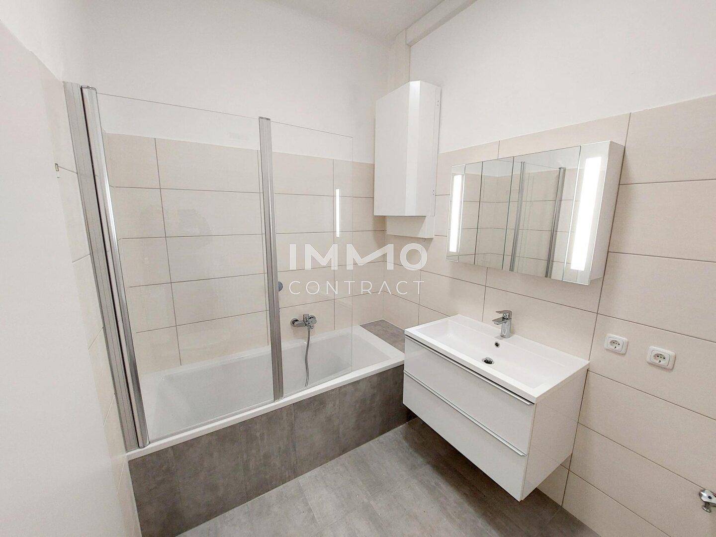 Helles Badezimmer mit Badewanne, modernem Waschtisch und Spiegelschrank, in gutem Zustand.