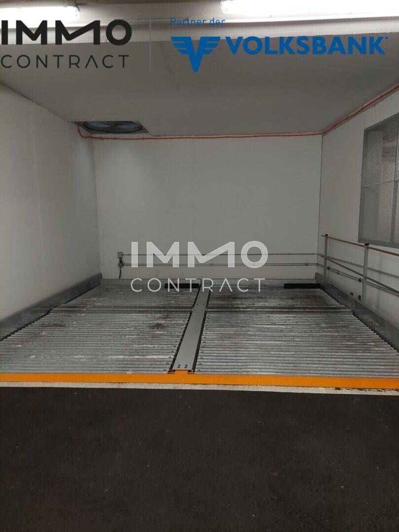 Innenansicht einer Tiefgarage mit einem mechanischen Parksystem und Betonboden.