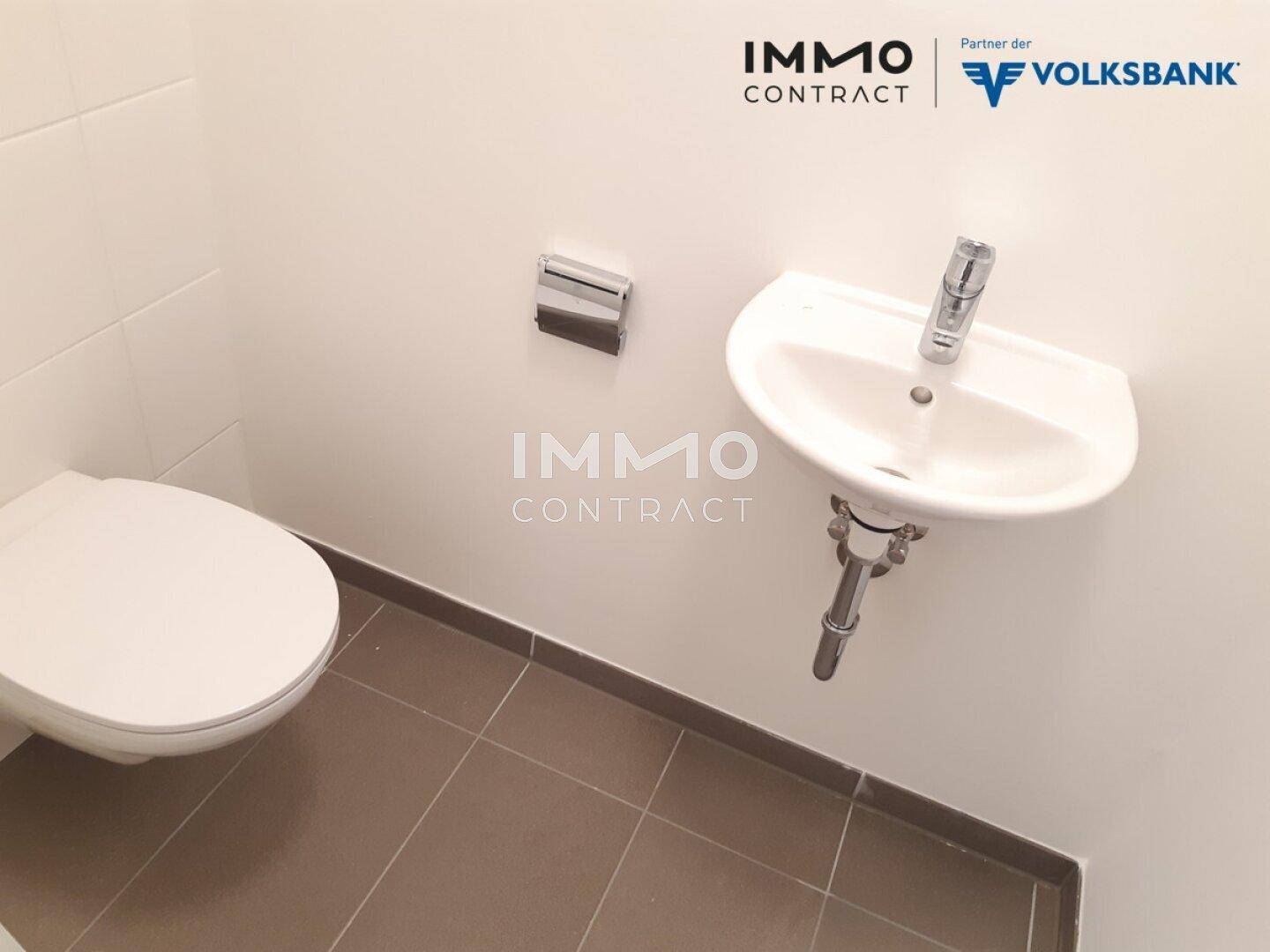 Separates Gäste-WC mit Wand-WC und kleinem Handwaschbecken.