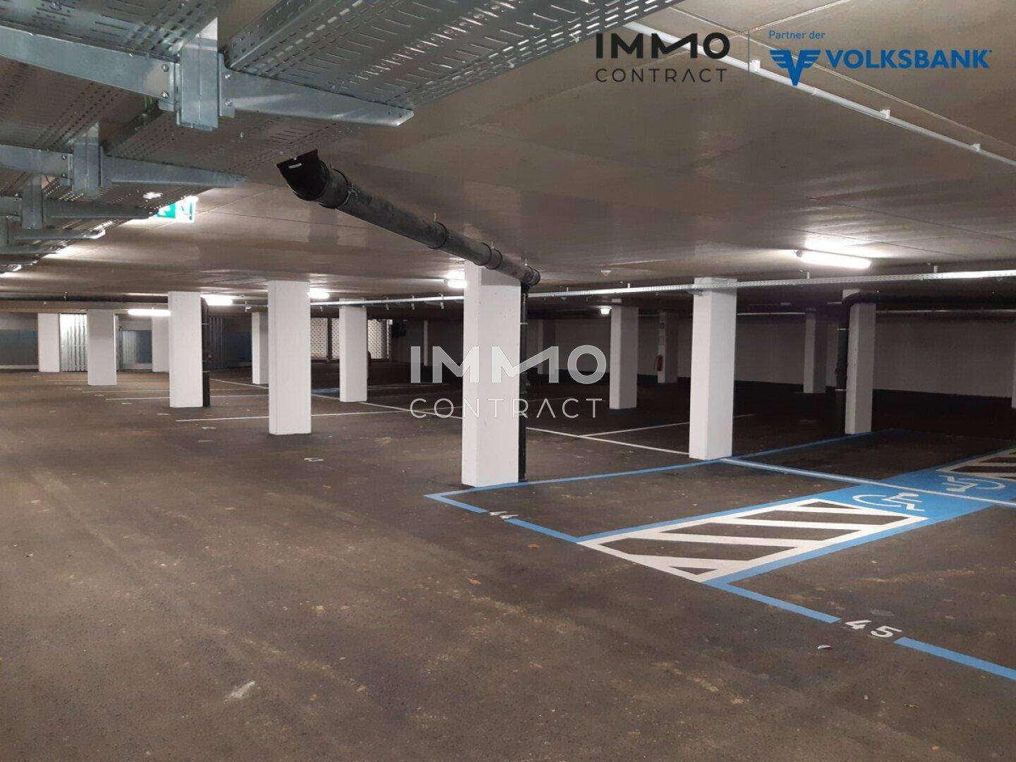 Geräumige Tiefgarage mit markierten Stellplätzen und Säulen in einem Neubau.