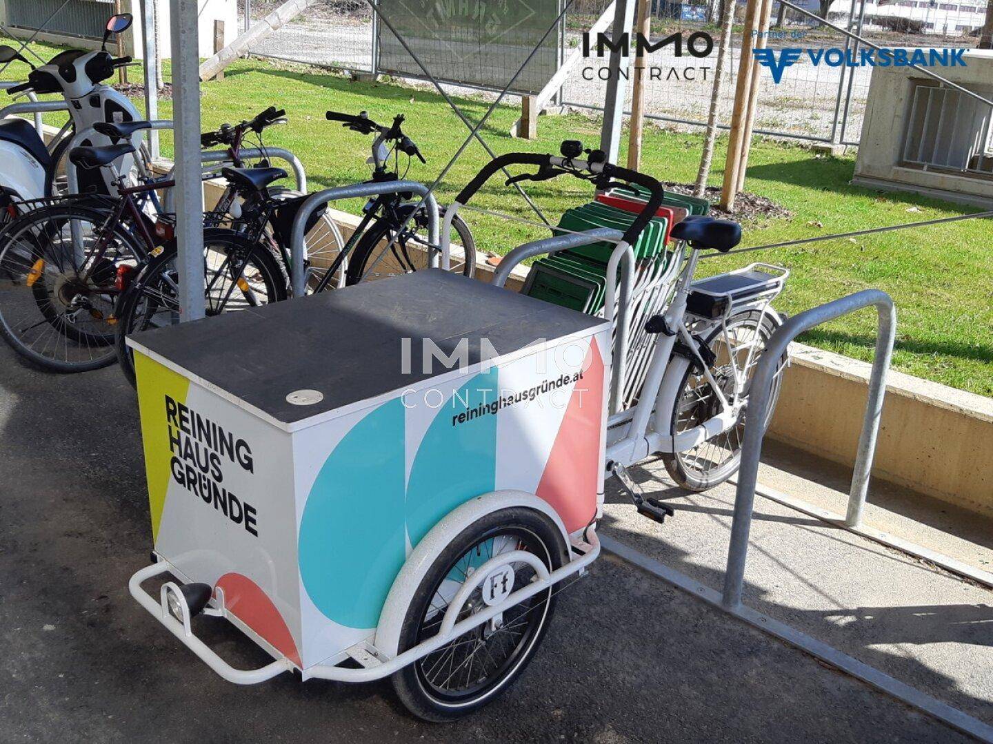 Fahrradabstellplatz im Freien mit verschiedenen Fahrrädern und einem Lastenrad.