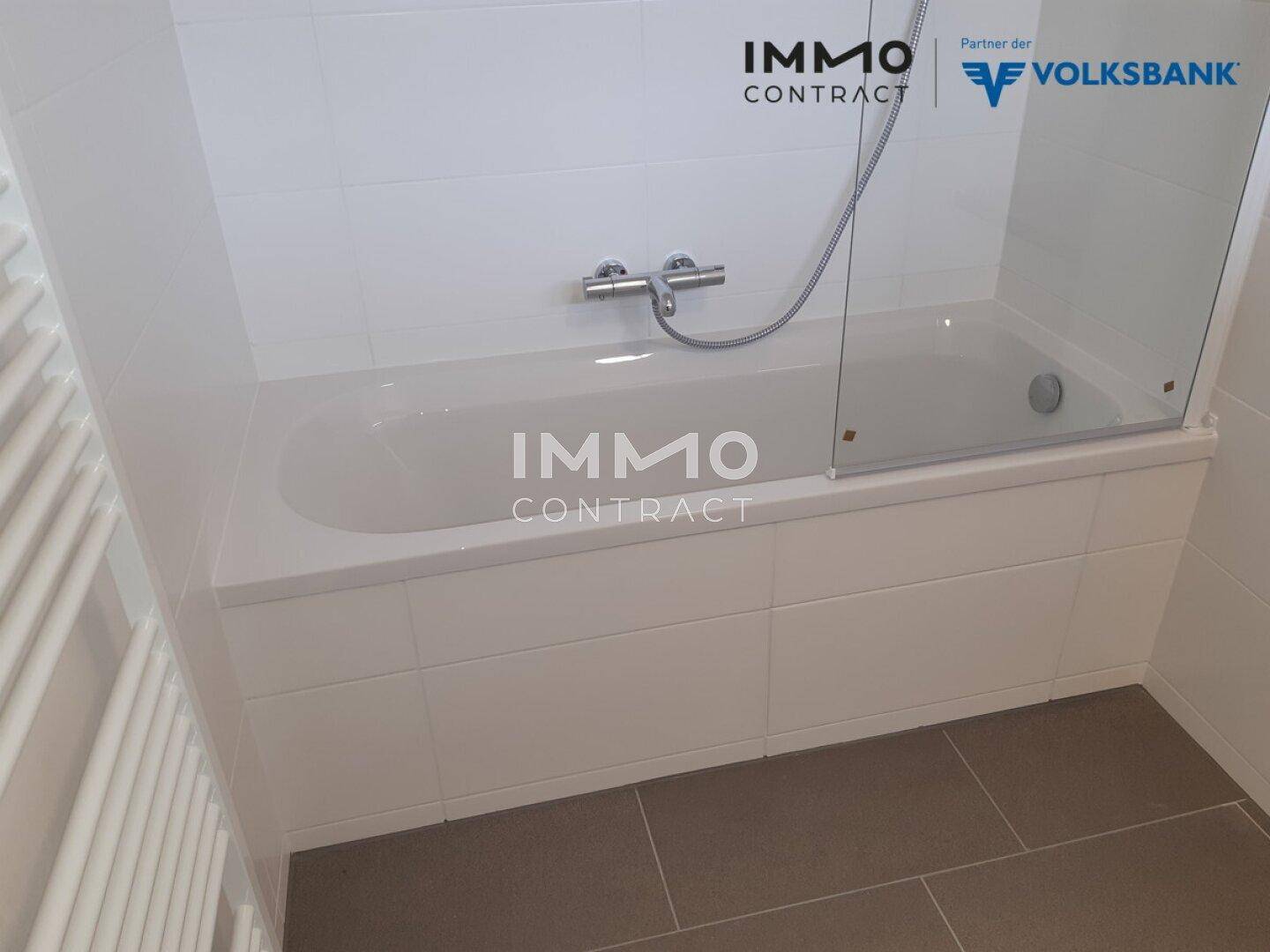 Badezimmer mit integrierter Badewanne und Duschabtrennung aus Glas.