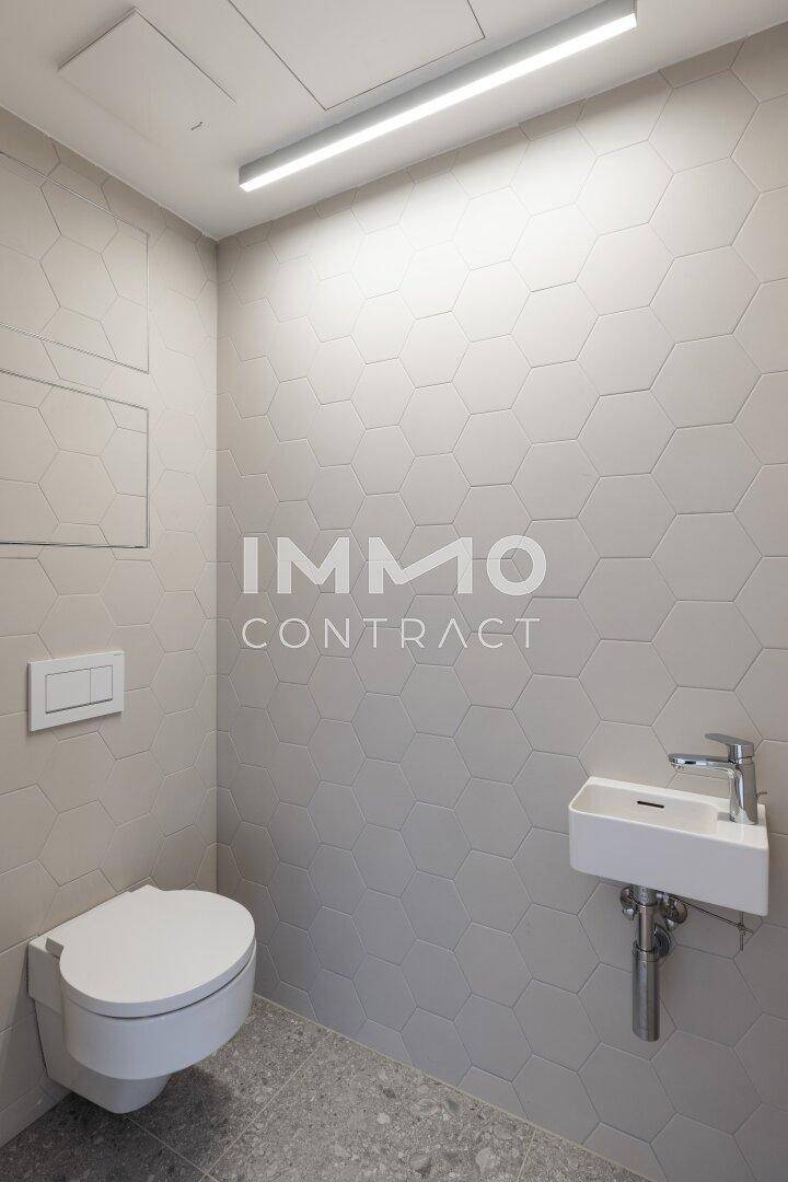 Modernes Gäste-WC mit Wand-WC, kleinem Waschbecken und sechseckigen Wandfliesen.