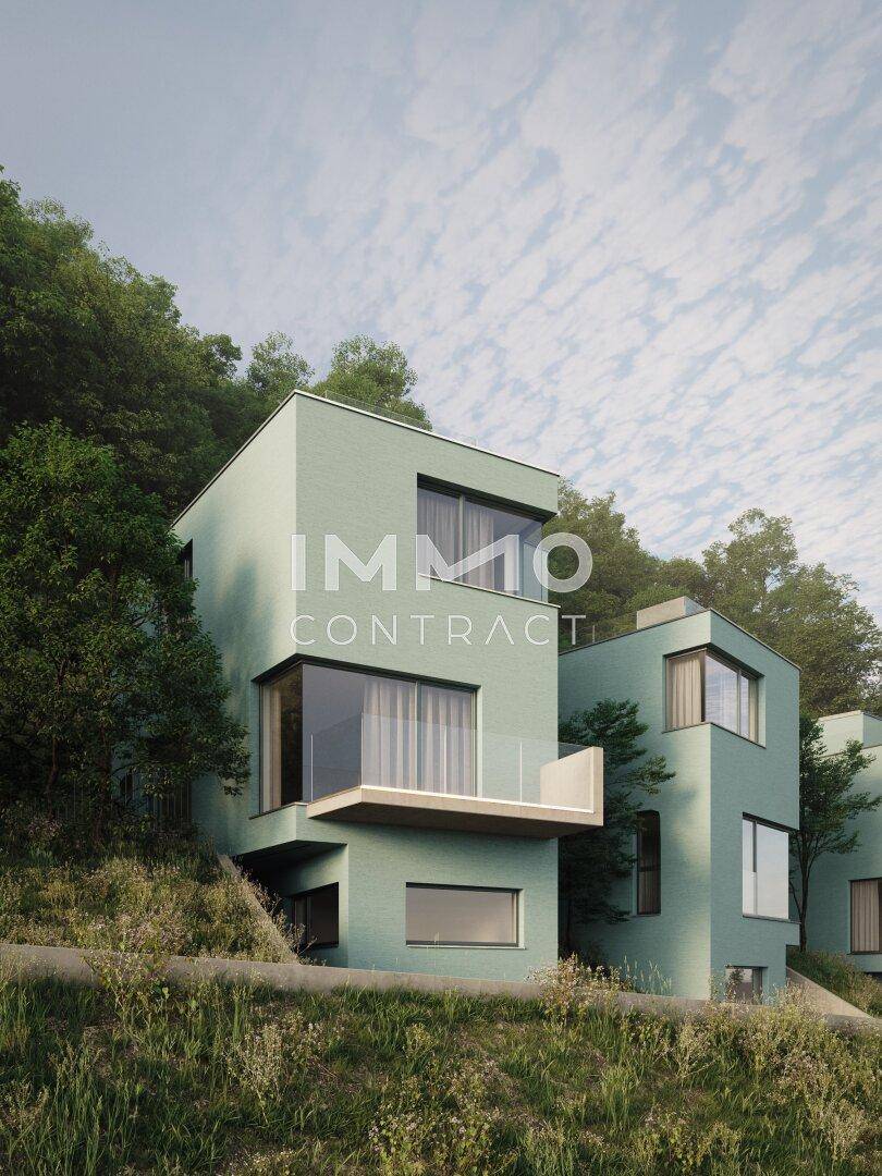 Einzelnes modernes Haus mit großen Fenstern und Balkon, eingebettet in eine grüne Umgebung.