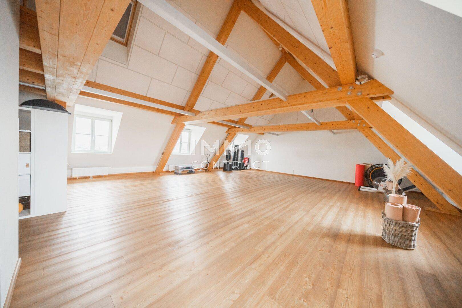 Heller Dachbodenraum mit Holzbalken und Schrägen, ausgestattet für sportliche oder kreative Aktivitäten.