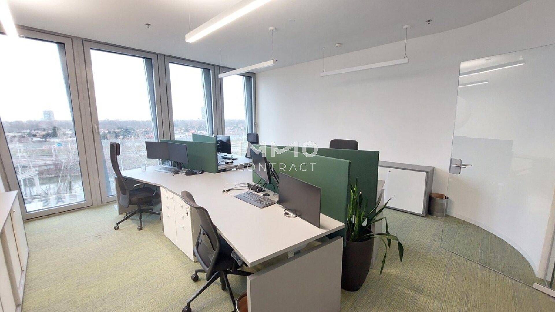 Offener Bürobereich mit modernen Schreibtischen, ergonomischen Stühlen und weitem Ausblick.
