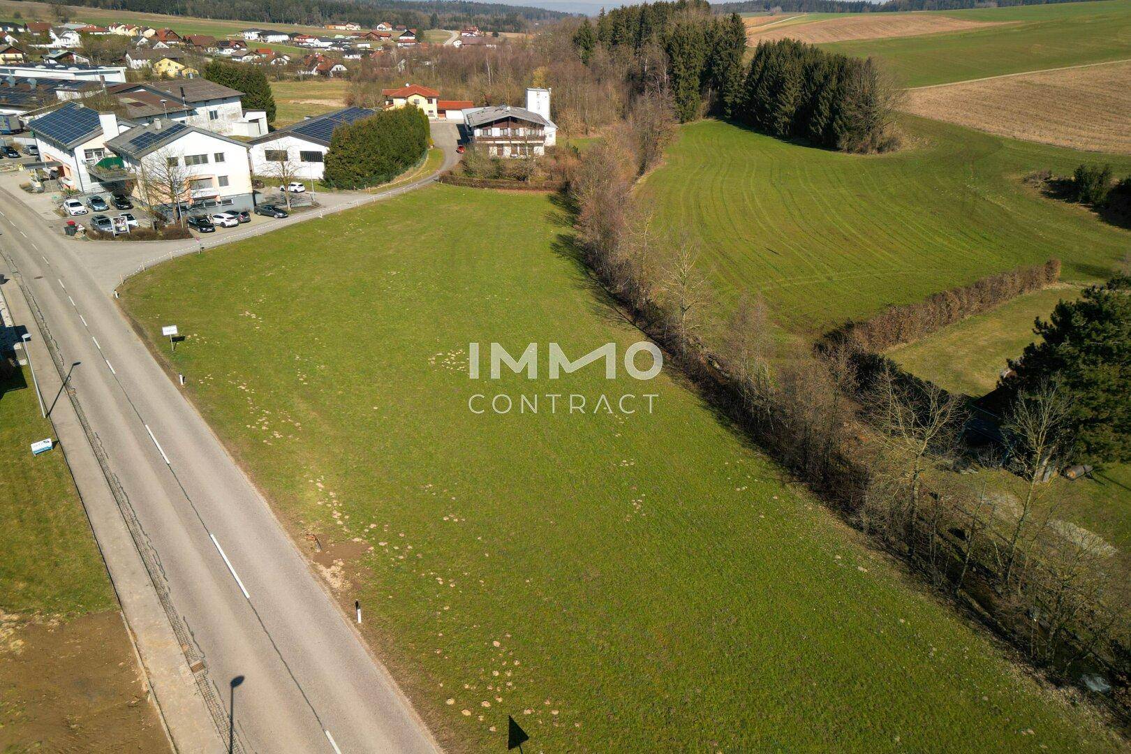 Luftaufnahme eines großen grünen Grundstücks mit angrenzender Straße und Blick auf die umliegende Bebauung.