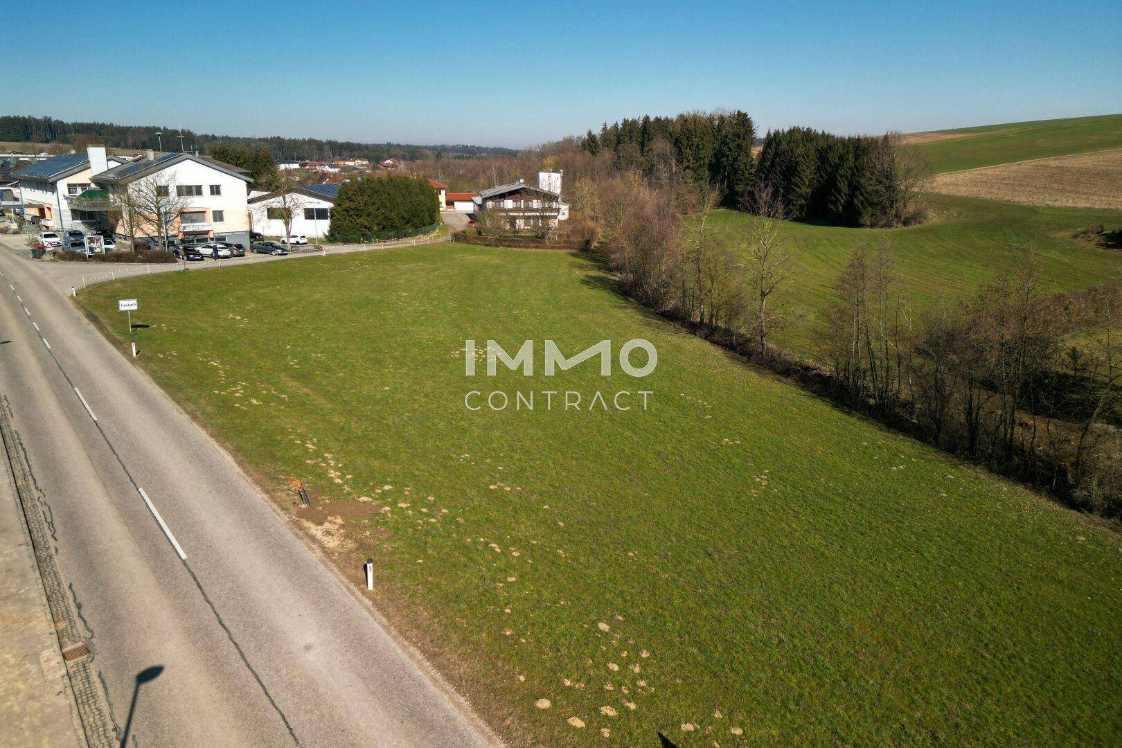 Weitläufiges grünes Grundstück mit angrenzender Straße und Blick auf die umliegende Wohnbebauung.