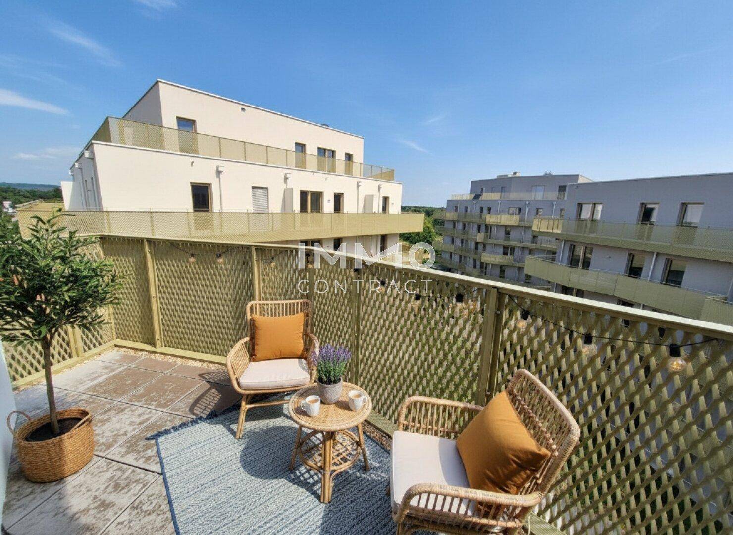 Möblierter Balkon mit Sitzgelegenheiten und Blick auf die umliegenden Gebäude.