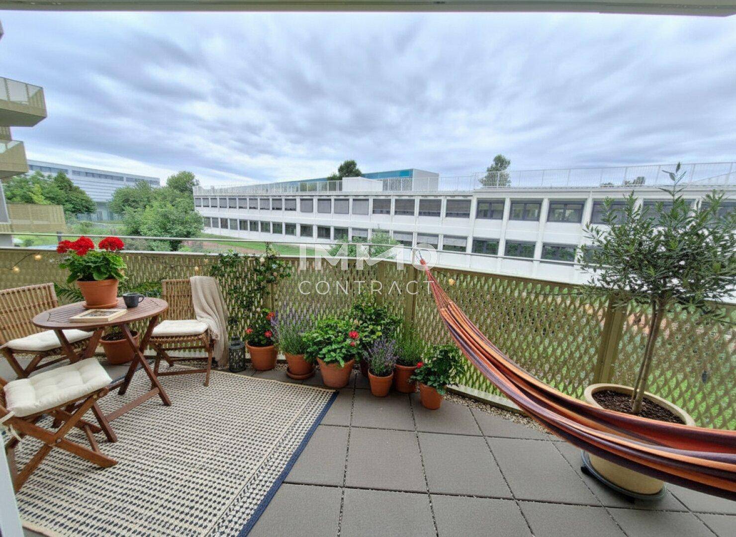 Gemütlicher Balkon mit Sitzgelegenheiten, Pflanzen und Hängematte, ideal zum Entspannen im Freien.