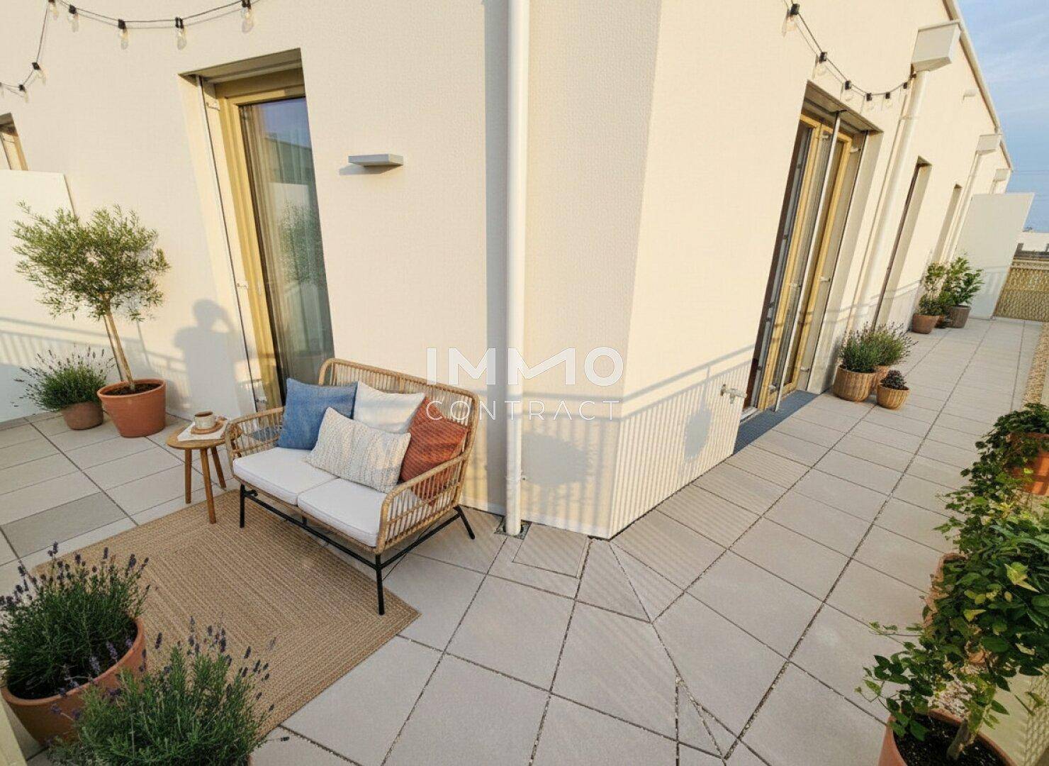 Sonniger Terrassenbereich mit Fliesenboden, Outdoor-Sitzgelegenheiten und dekorativen Pflanzen für Entspannung.