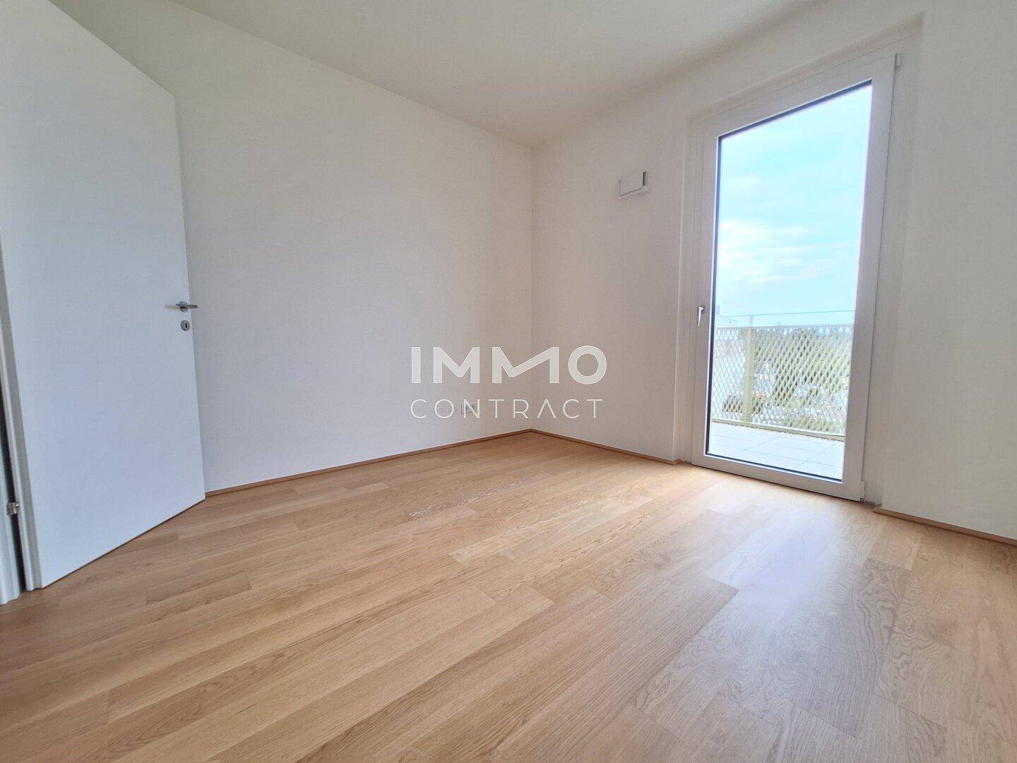Leerer Raum mit Parkettboden und Balkonzugang, ideal für Schlaf- oder Arbeitszimmer.