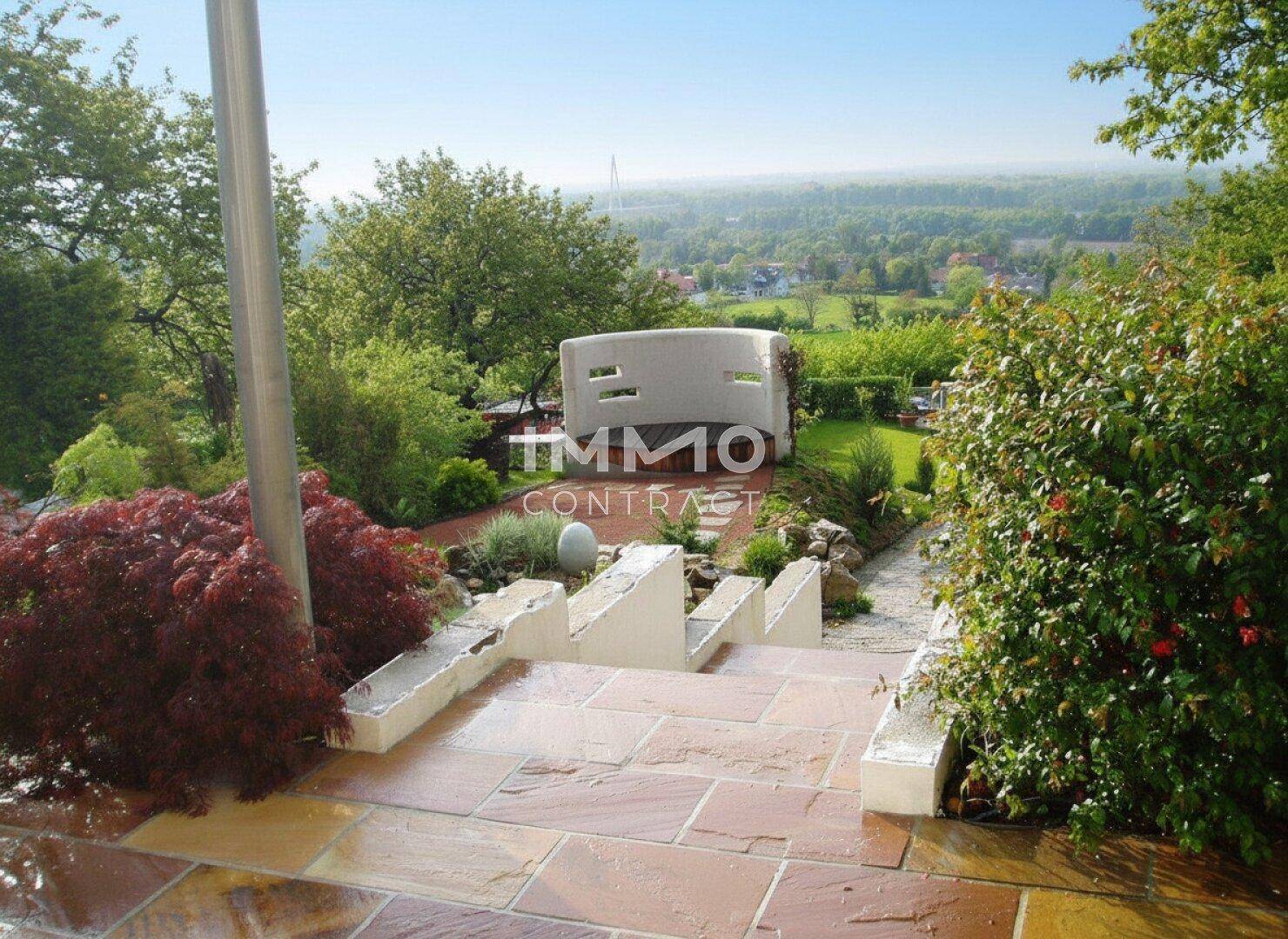 Steintreppe im Garten mit weitem Blick über die Landschaft und grüne Umgebung.