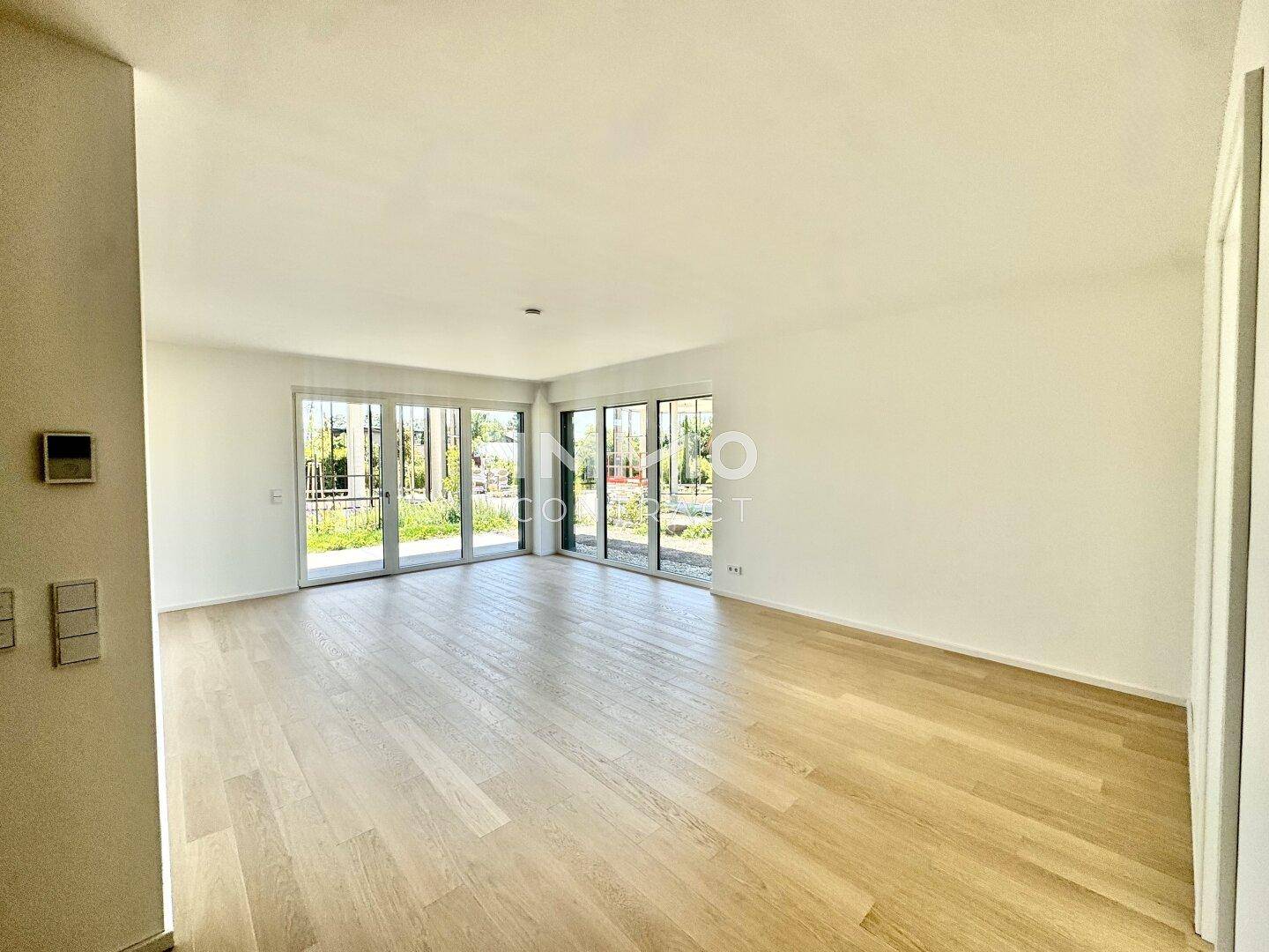 Geräumiges, helles Wohnzimmer mit Holzboden und großen Fenstern zum Garten.