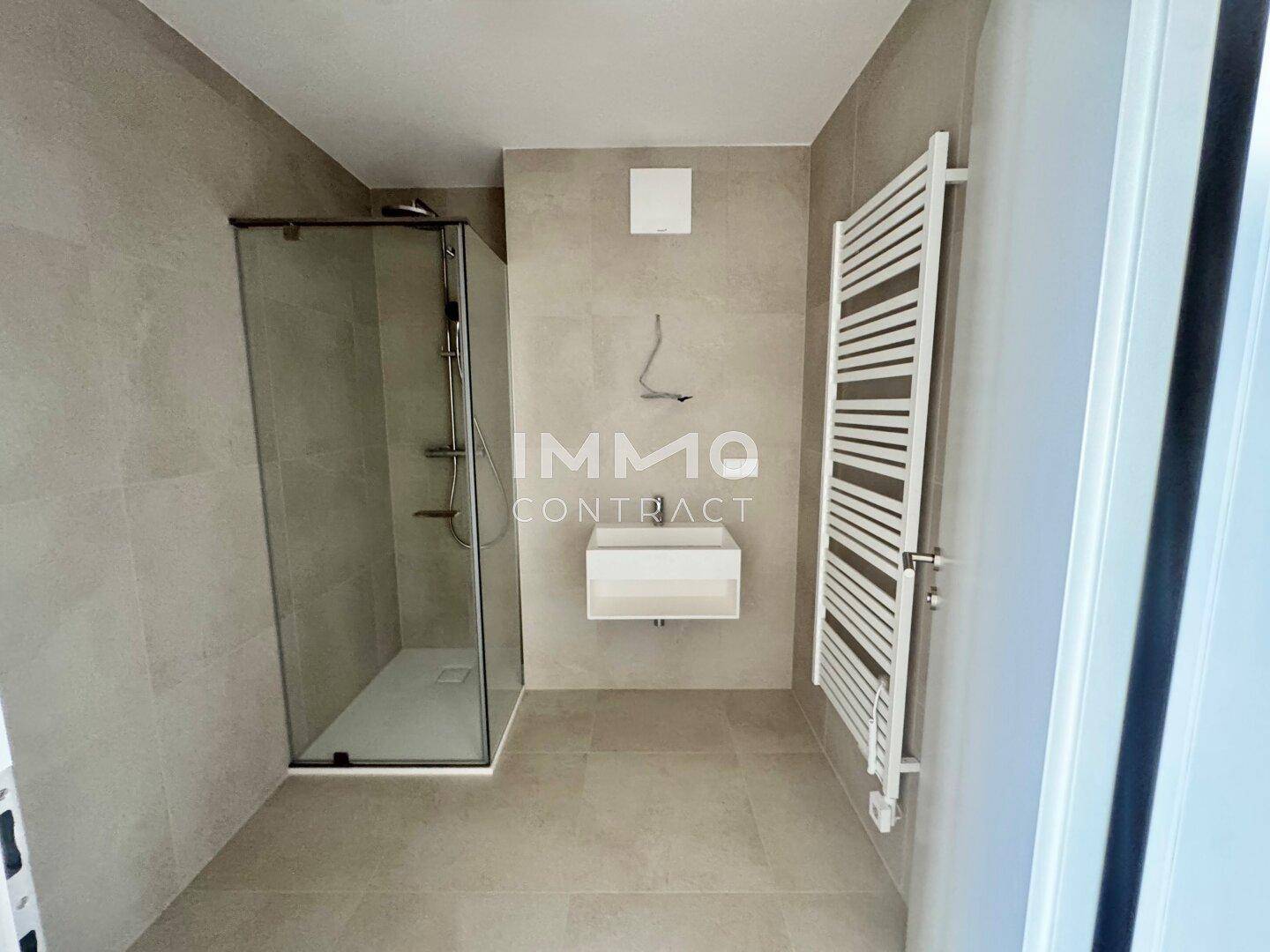 Modernes Badezimmer mit begehbarer Dusche, Wandwaschbecken und Handtuchheizkörper.