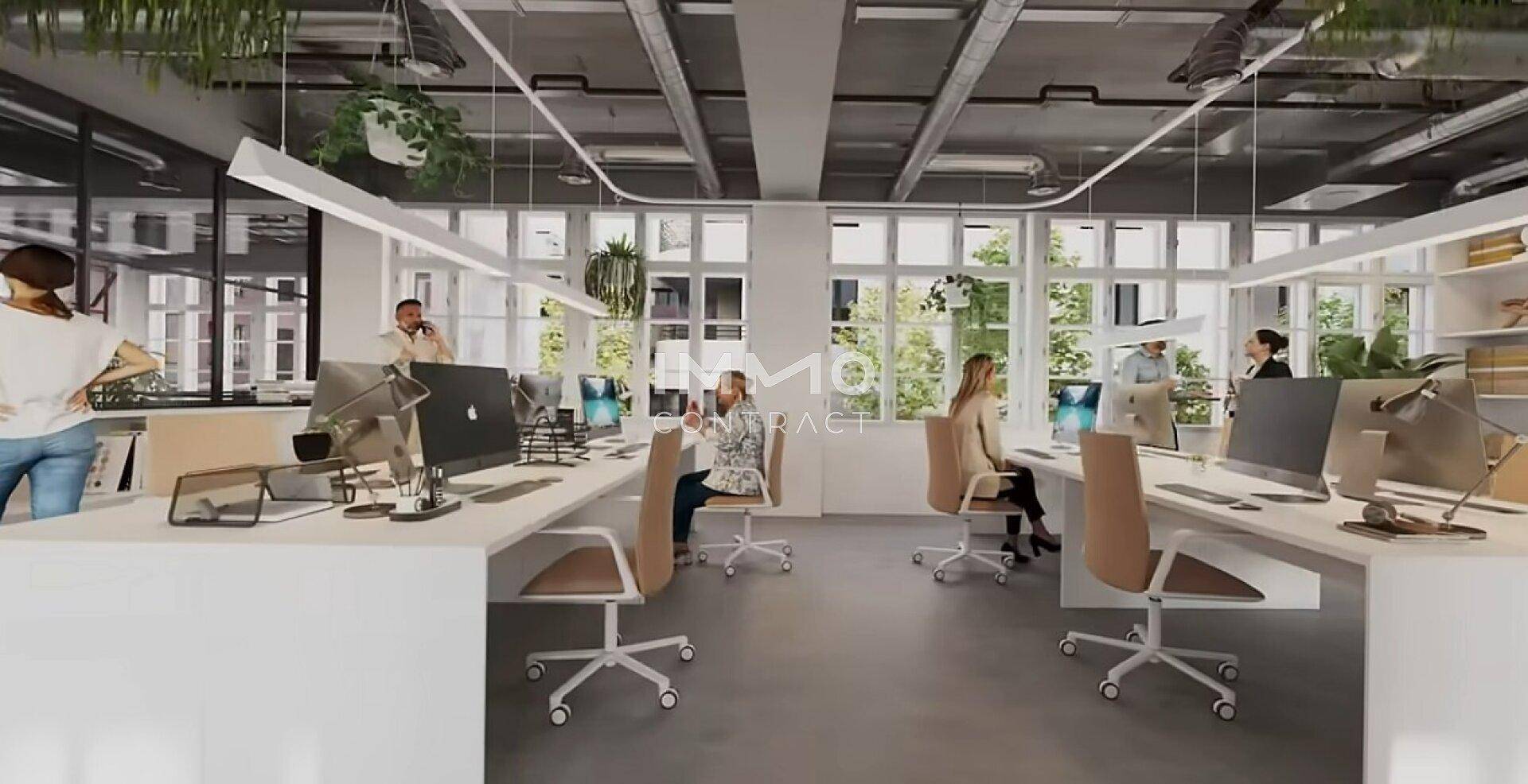 Helles Großraumbüro mit modernen Arbeitsplätzen, großen Fenstern und industriellem Design.