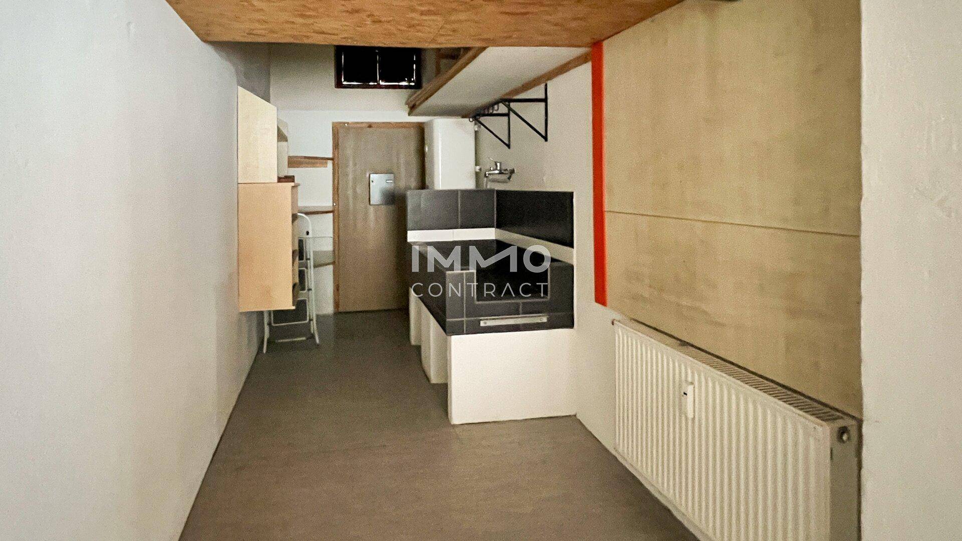 Kleine Küchenzeile oder Abstellraum mit Spülbecken, Heizkörper und einfacher Ausstattung unter einer Holzdecke.