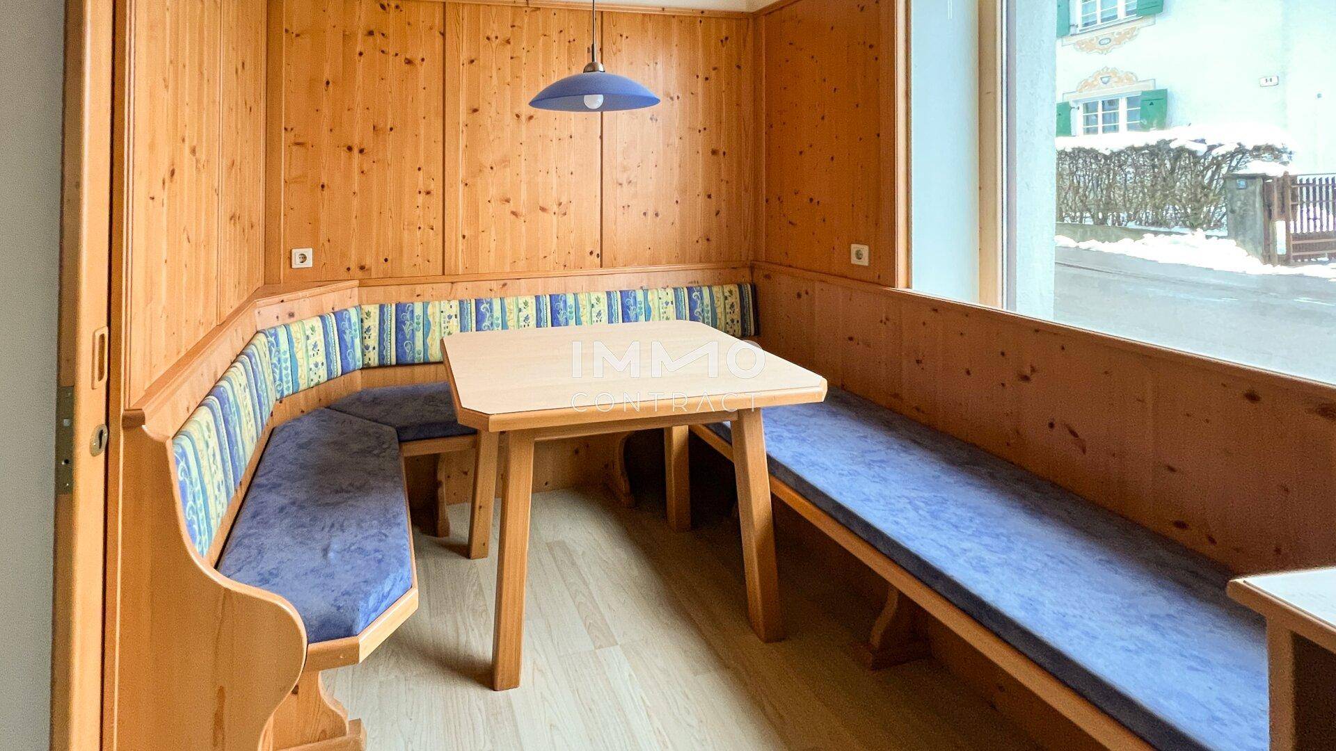 Gemütlicher Essbereich mit Holztäfelung, Eckbank und einem Fenster mit Blick nach draußen, traditionell eingerichtet.