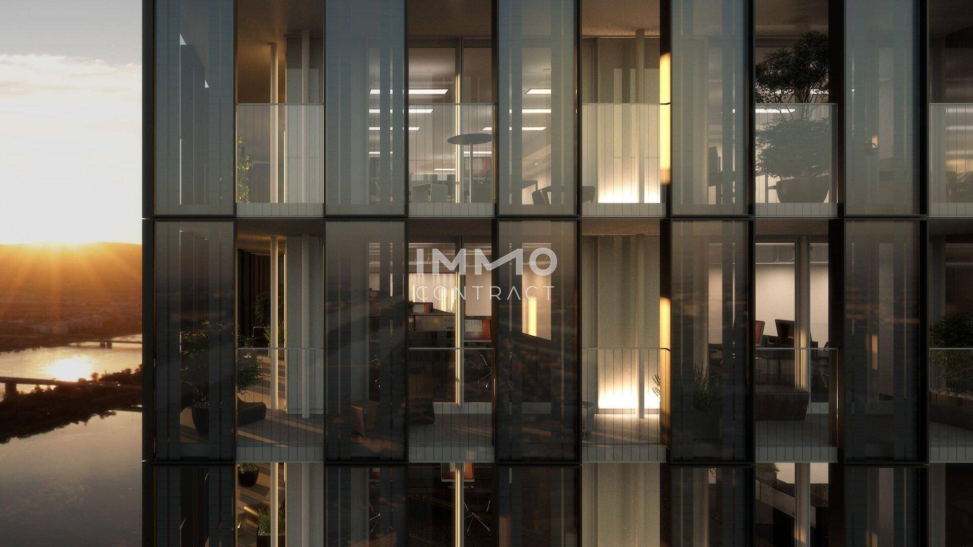 Detailansicht einer modernen Hochhausfassade mit Glasfronten und Balkonen bei Sonnenuntergang.