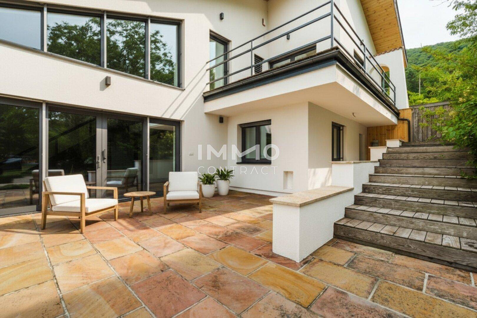 Sonniger Terrassenbereich mit bequemen Gartenmöbeln und Zugang zum Haus.