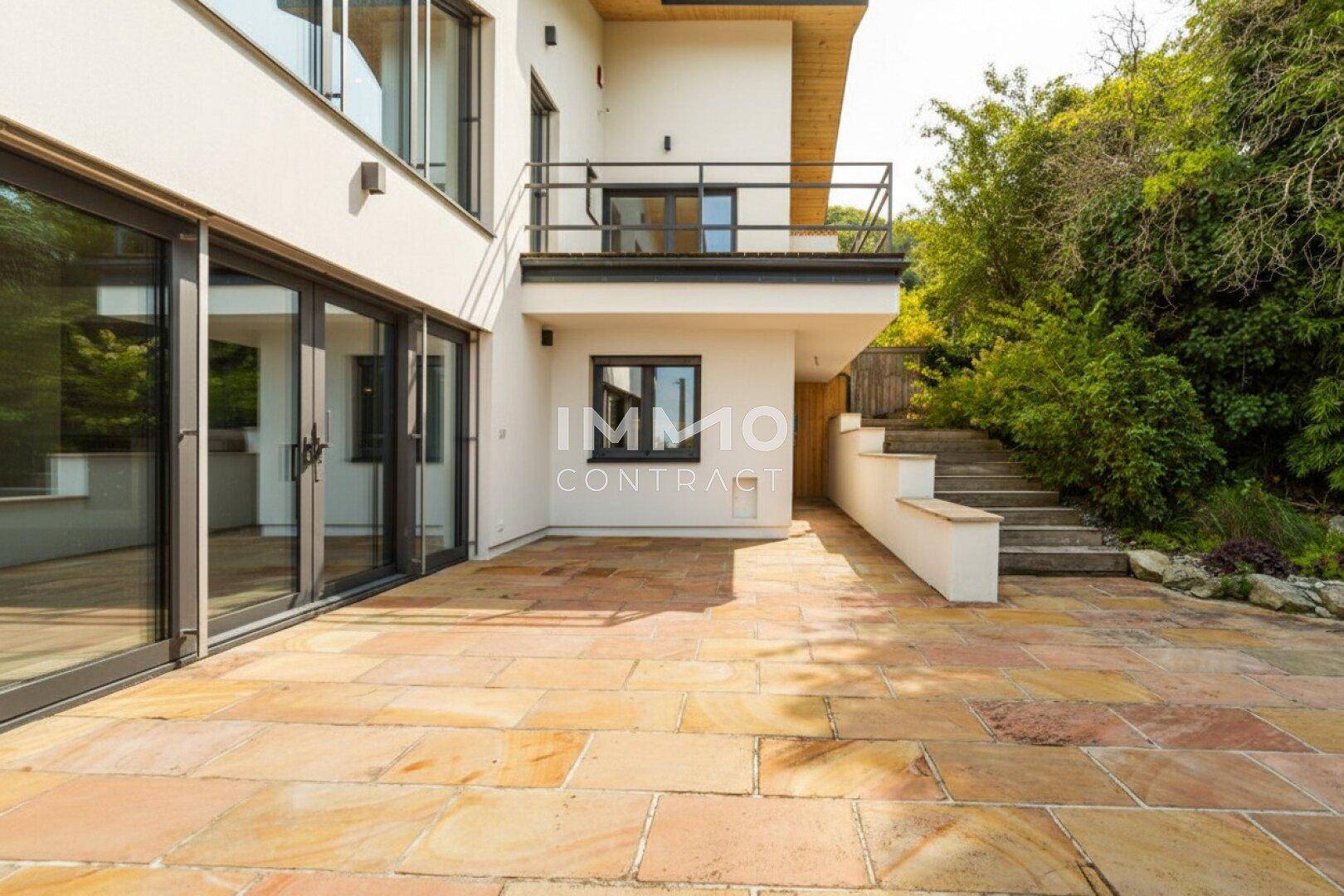 Geräumige Steinterrasse mit viel Platz für Outdoor-Möbel und direkten Zugang zum Garten.