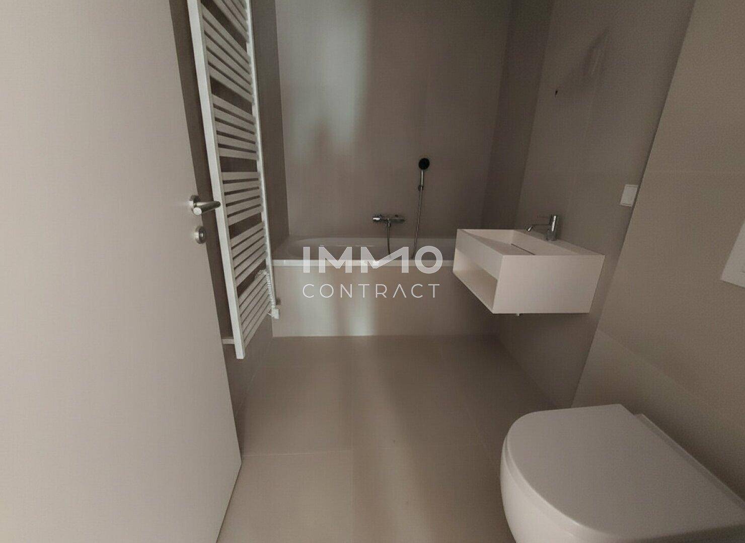 Modernes Badezimmer mit schwebendem Waschbecken, Wand-WC und beheiztem Handtuchhalter.