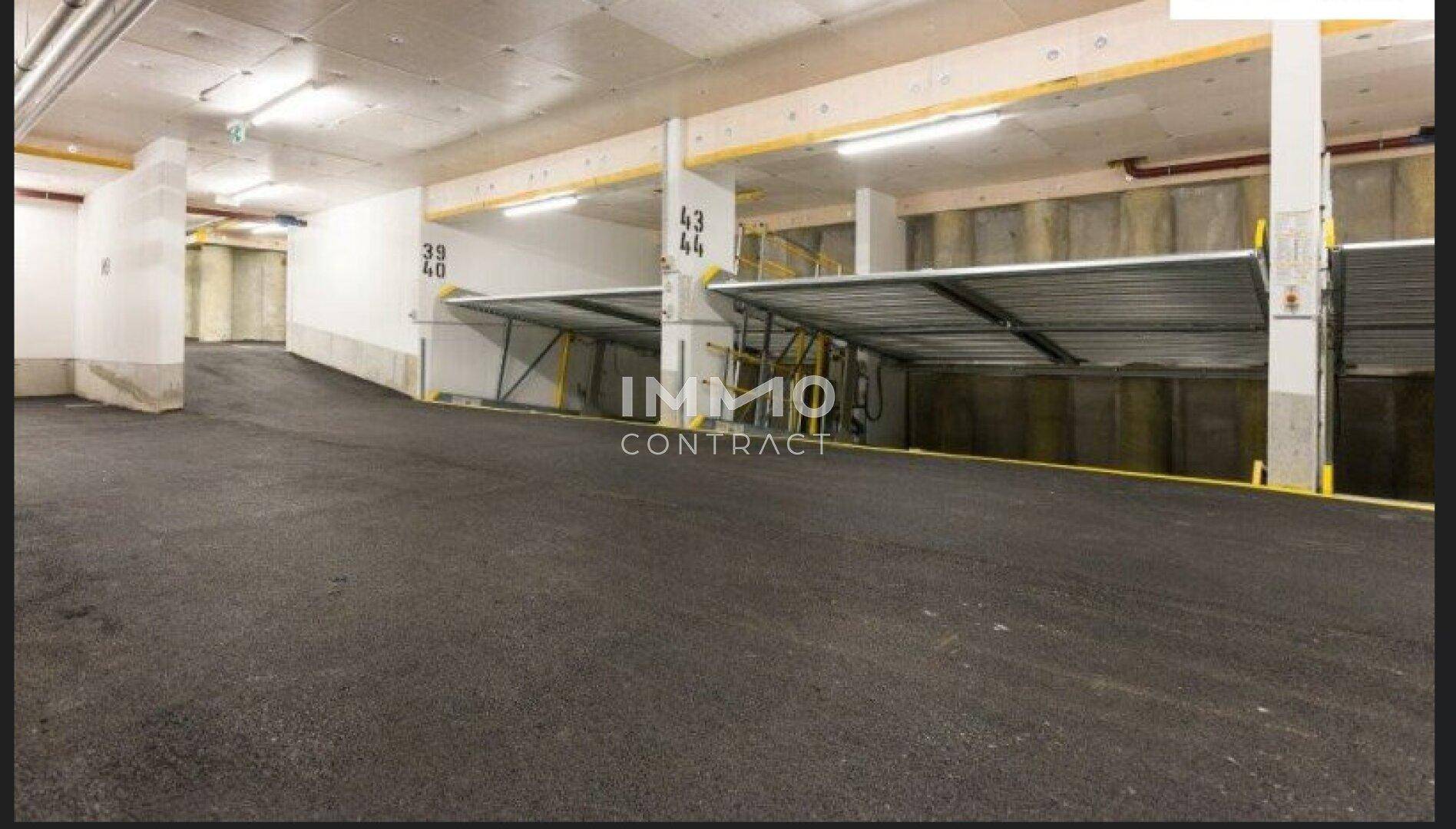 Helle Tiefgarage mit Doppelparkern und asphaltiertem Boden für mehrere Fahrzeuge.