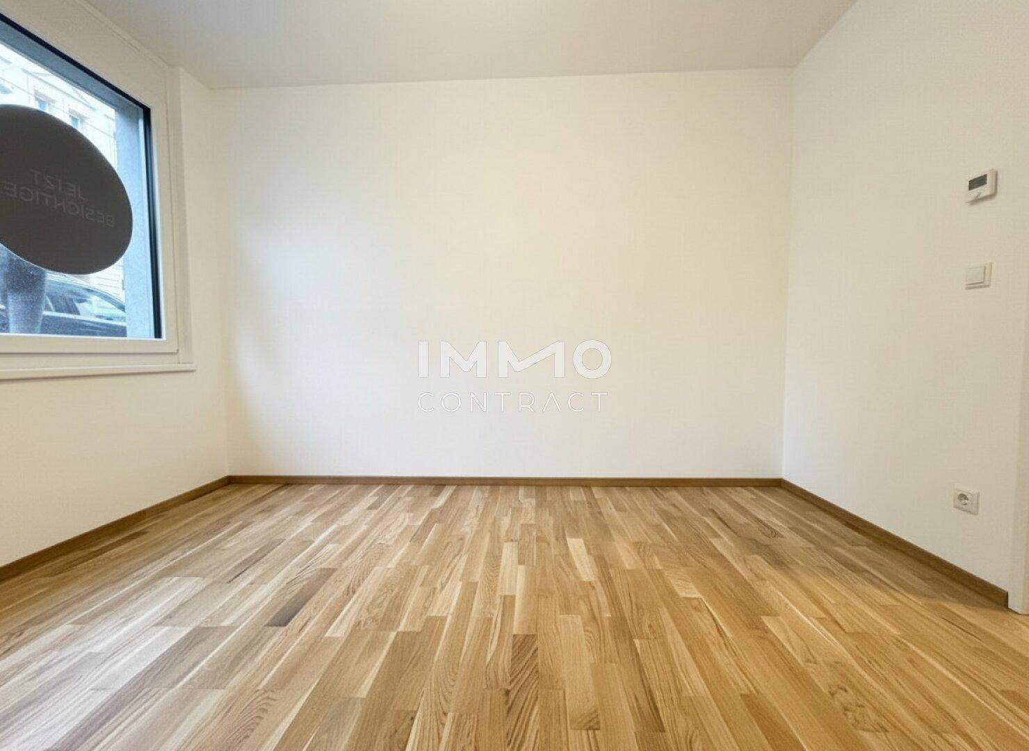Heller, leerer Raum mit Holzboden und einem Fenster, ideal für verschiedene Nutzungen und individuelle Gestaltungsmöglichkeiten.