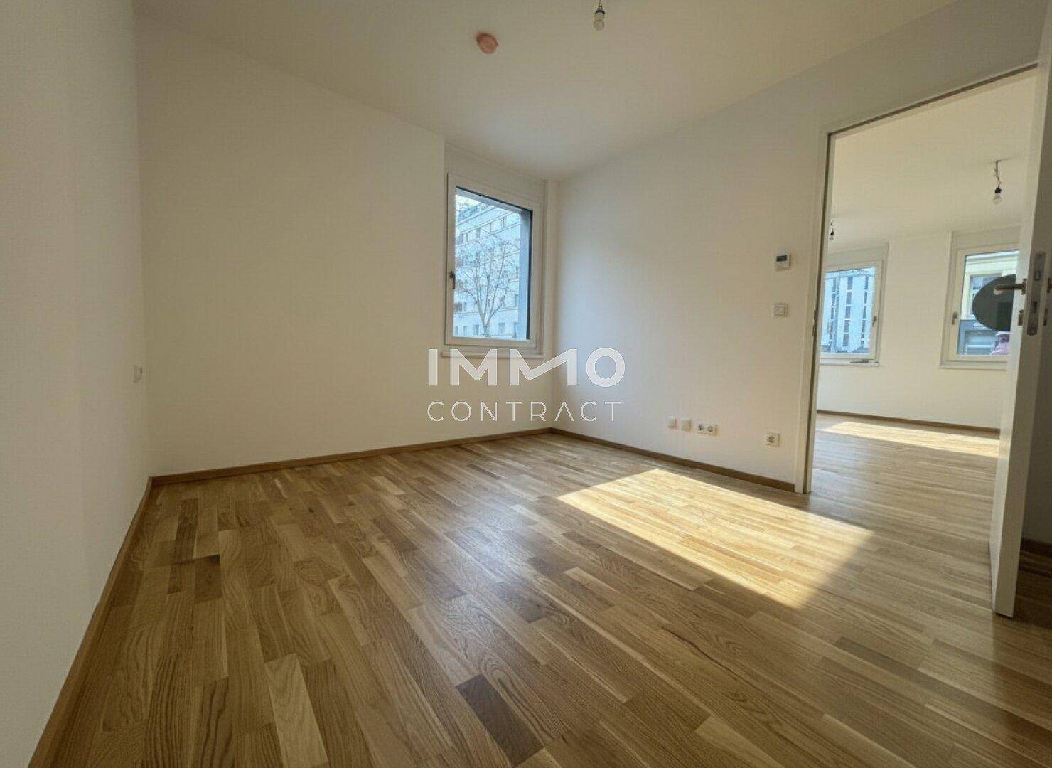 Leerer, heller Raum mit Holzboden und Fenster, bereit für individuelle Gestaltung und vielfältige Nutzungsmöglichkeiten.
