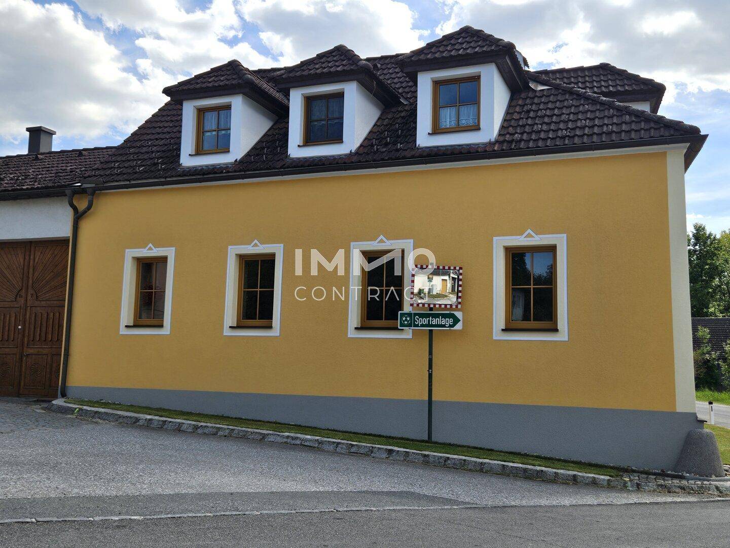 Seitenansicht des gelben Gebäudes mit traditioneller Architektur und einem Straßenschild.