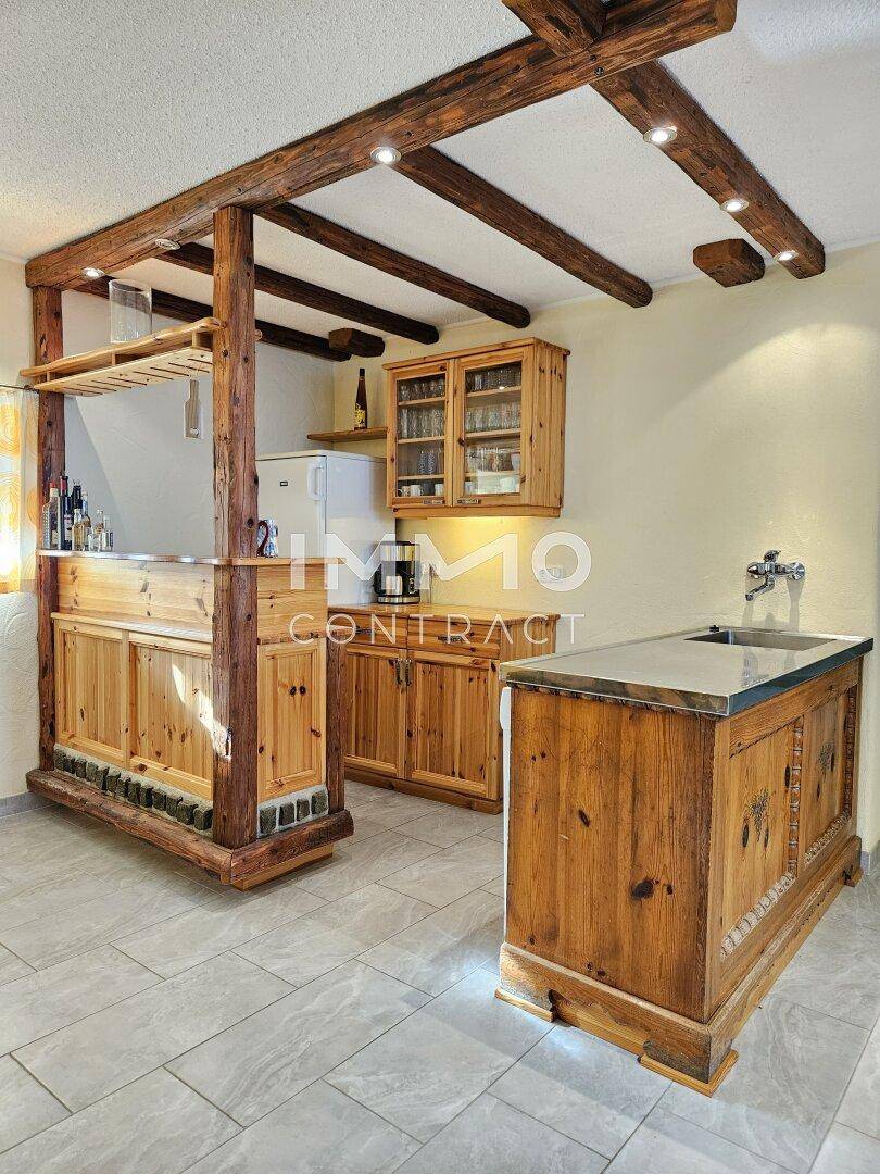 Rustikale Holzbar mit Zapfanlage und Regalen, integriert in den großen Essbereich.