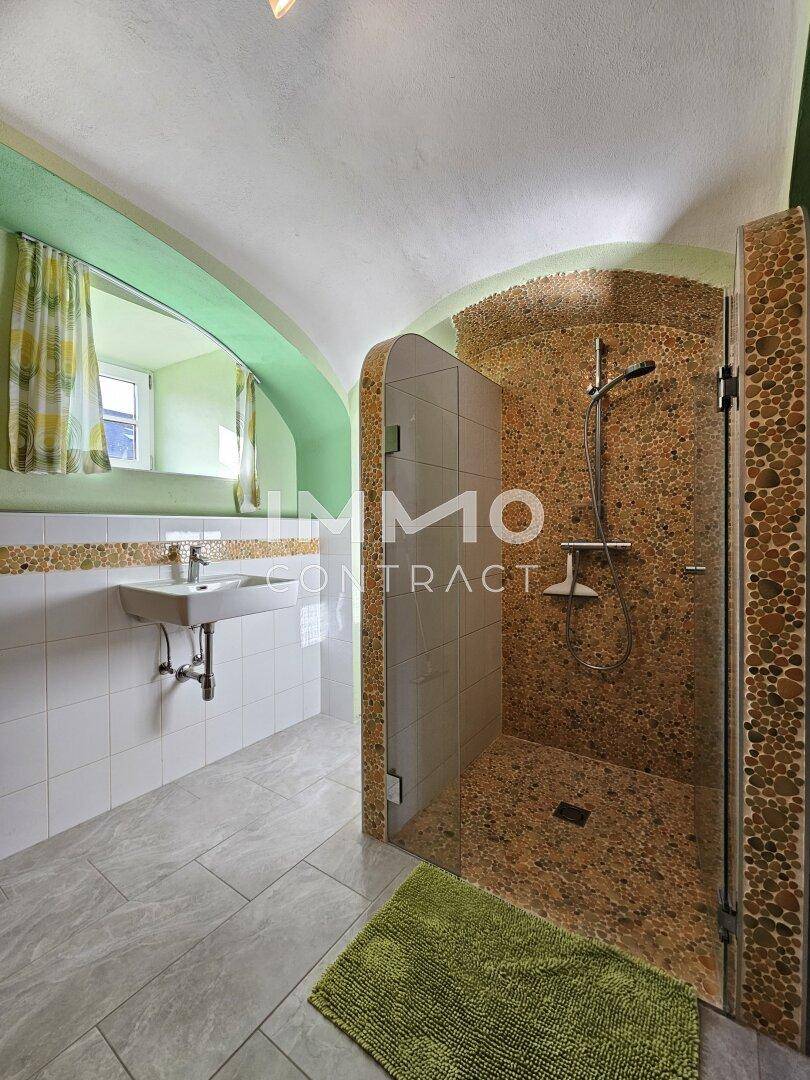 Modernes Badezimmer mit begehbarer Dusche, Mosaikfliesen und einem Fenster.