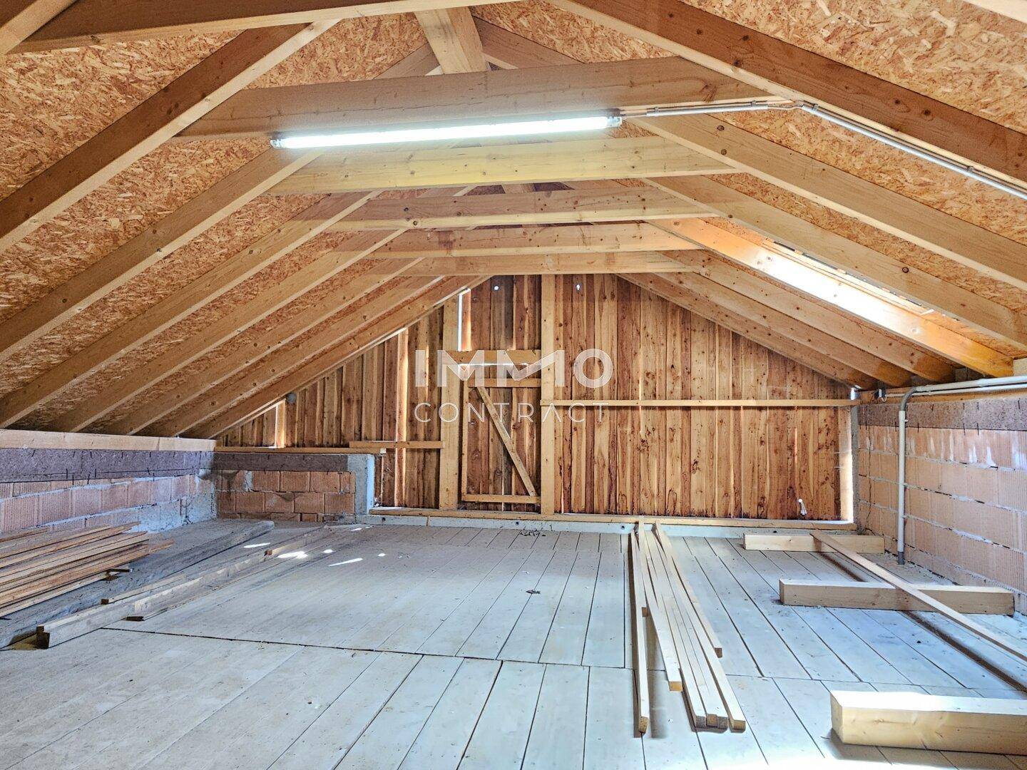Unausgebauter Dachboden mit sichtbaren Holzbalken und Dielenboden, bietet Ausbaupotenzial.