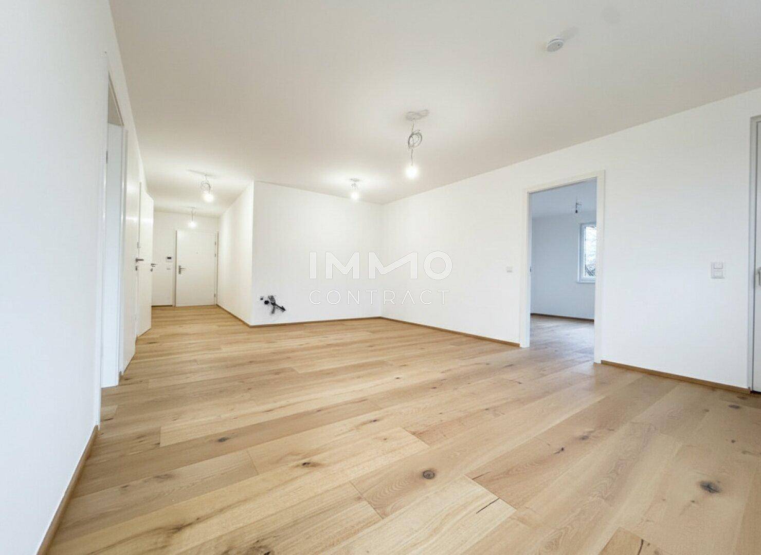 Heller Flur mit modernem Holzparkettboden, der zu verschiedenen Räumen führt.