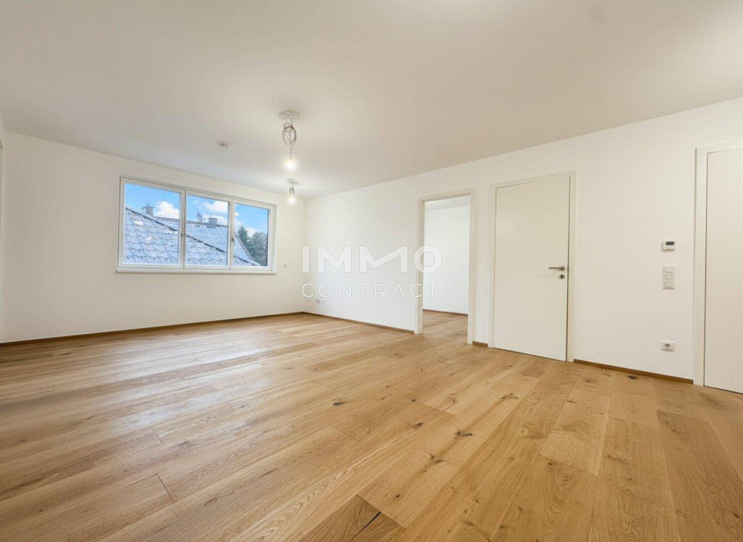 Helles, geräumiges Wohnzimmer mit neuem Holzparkettboden und Blick ins Grüne.