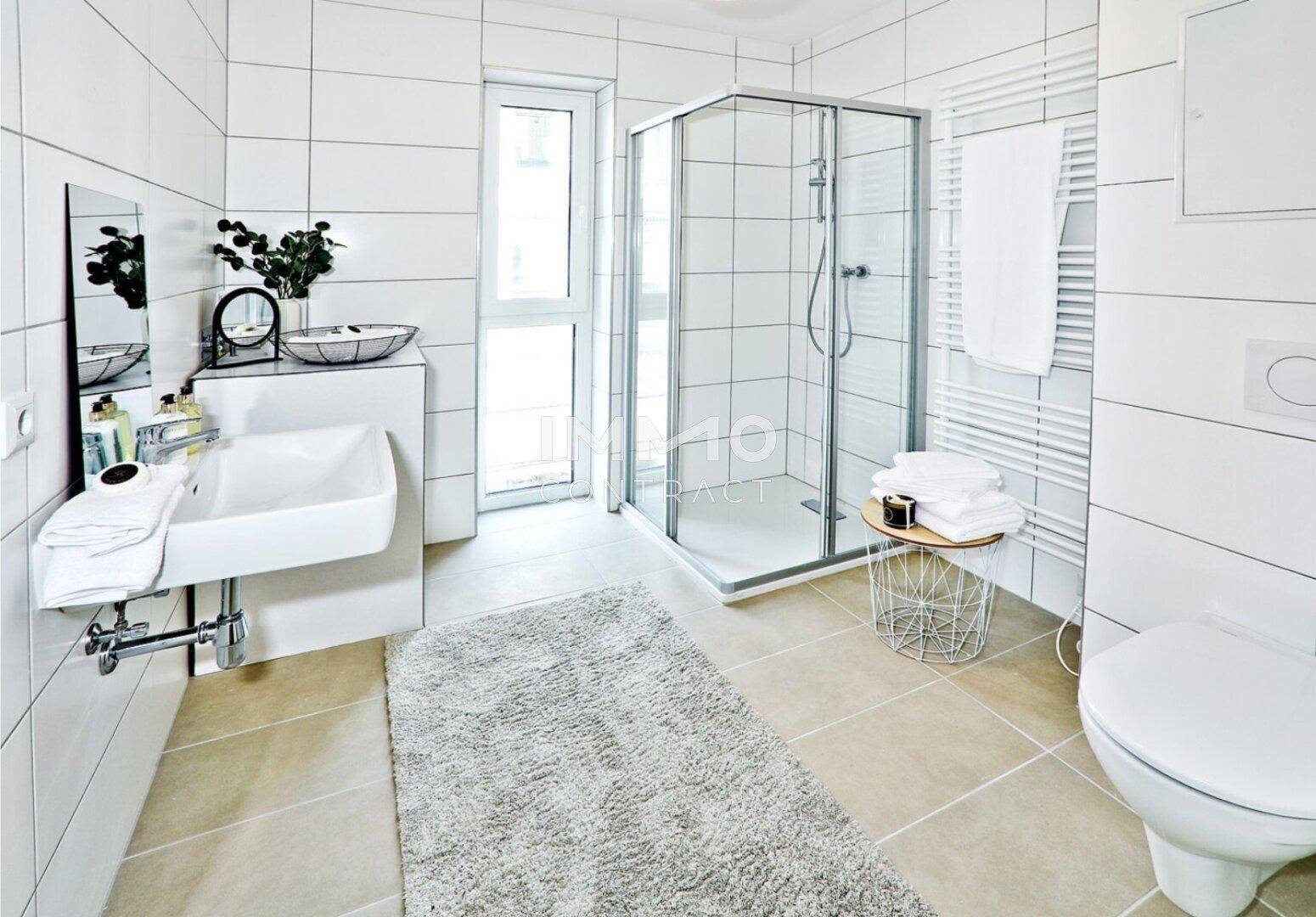 Modernes Badezimmer mit Duschkabine, Fenster und weiß gefliesten Wänden.