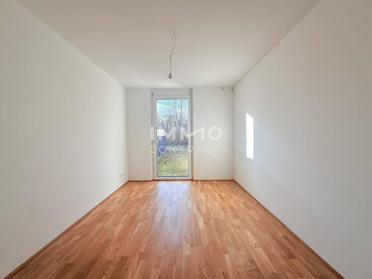 Freundliches Zimmer mit Parkettboden und direktem Zugang zum Gartenbereich.