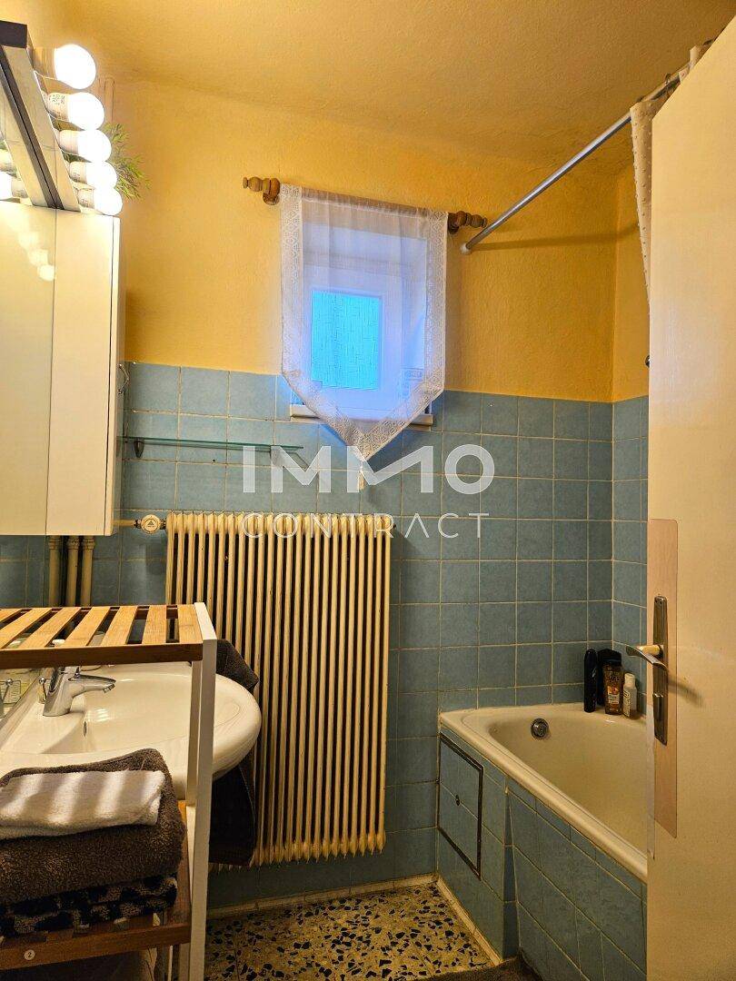 Badezimmer im Stil der 80er Jahre mit blauen Fliesen und Badewanne.