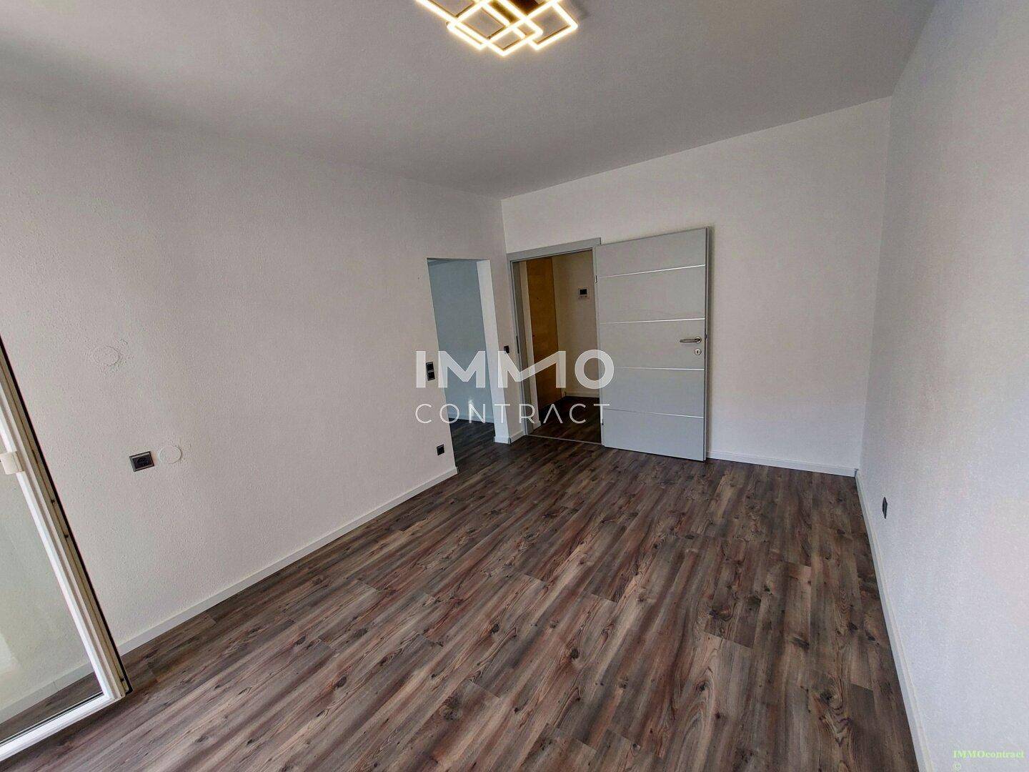Geräumiger, heller Raum mit Laminatboden und weiß gestrichenen Wänden.