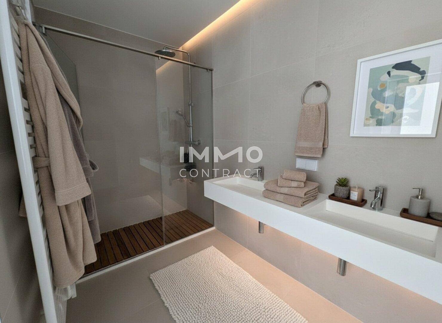 Modernes Badezimmer mit begehbarer Dusche, eleganten Fliesen und einem einzelnen Waschbecken.