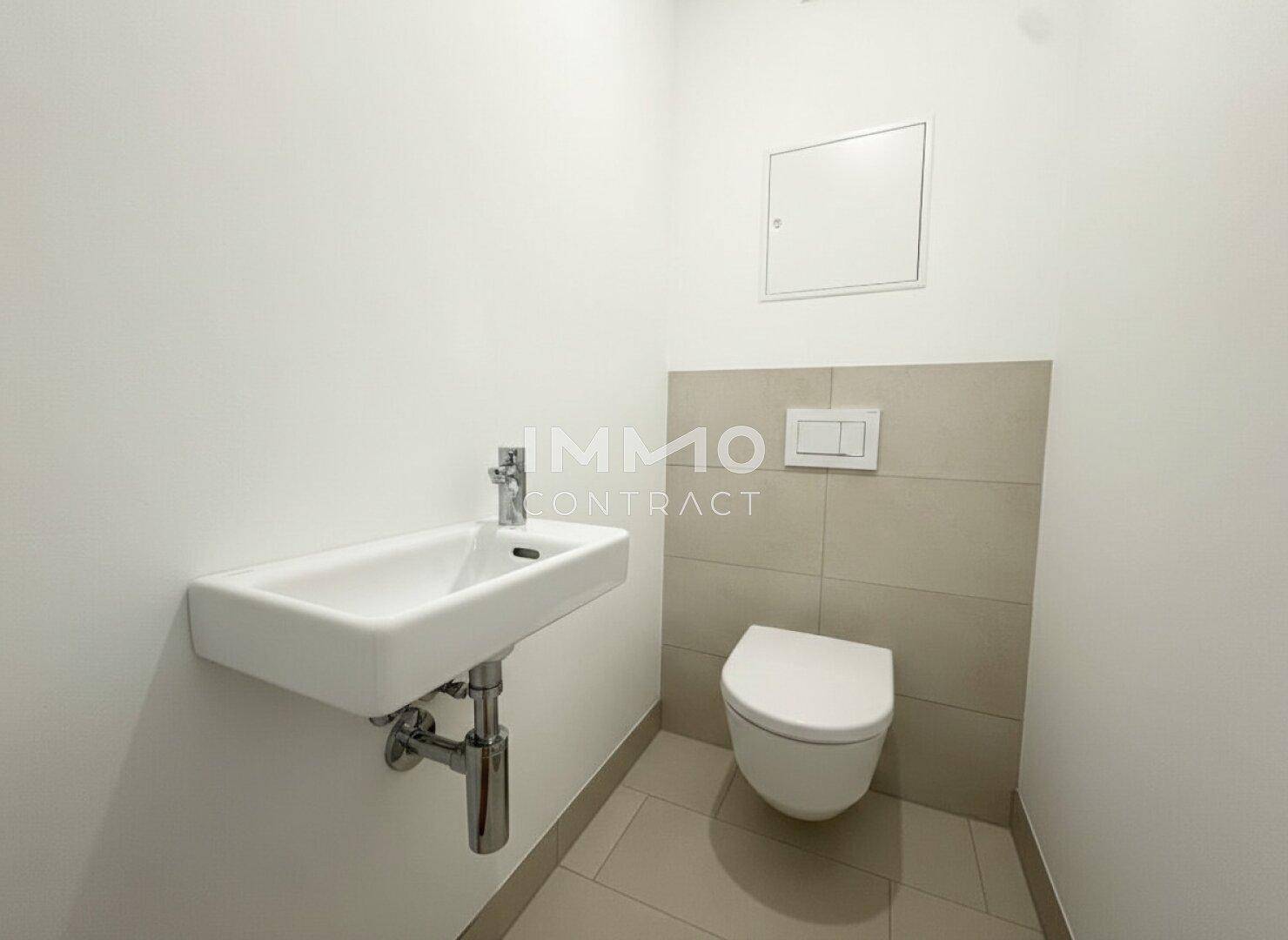 Kompaktes Gäste-WC mit wandhängender Toilette und kleinem Waschbecken.
