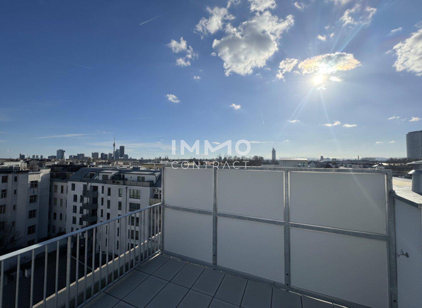 Helle Dachterrasse mit Panoramablick auf die Stadt unter strahlendem Sonnenschein.