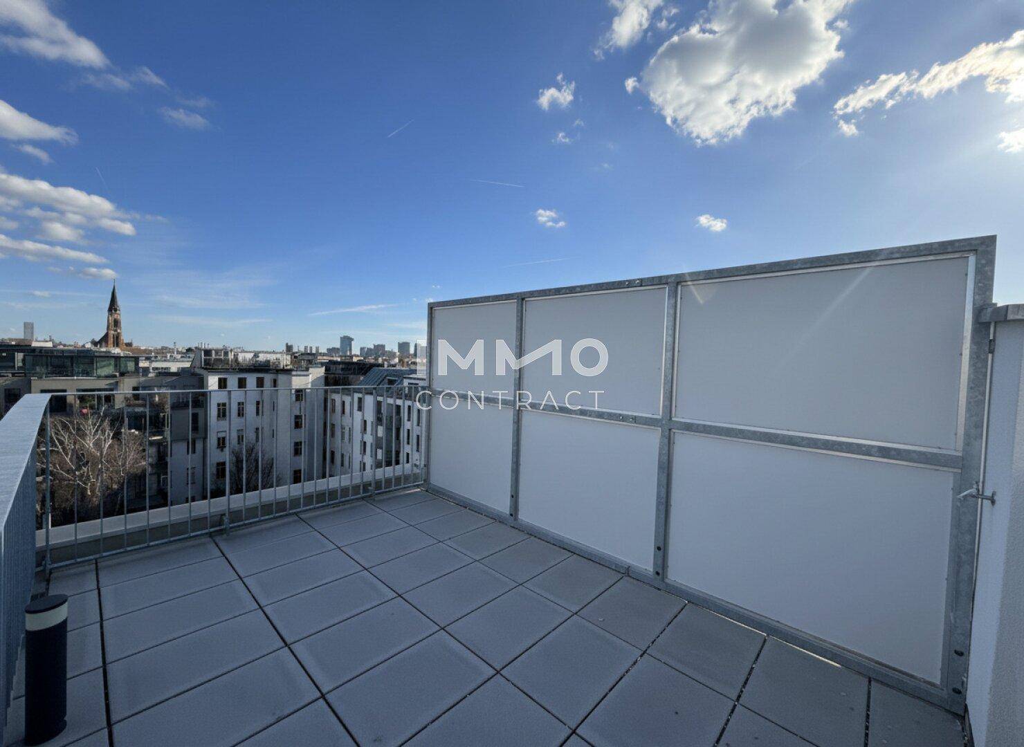 Sonnige Dachterrasse mit Sichtschutz und weitem Blick über die Stadtlandschaft.