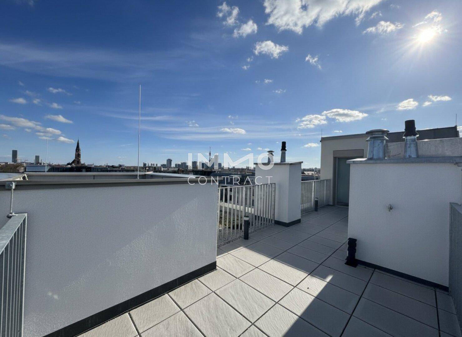 Weitläufige Dachterrasse mit Fliesenboden und Panoramablick über die Stadt.
