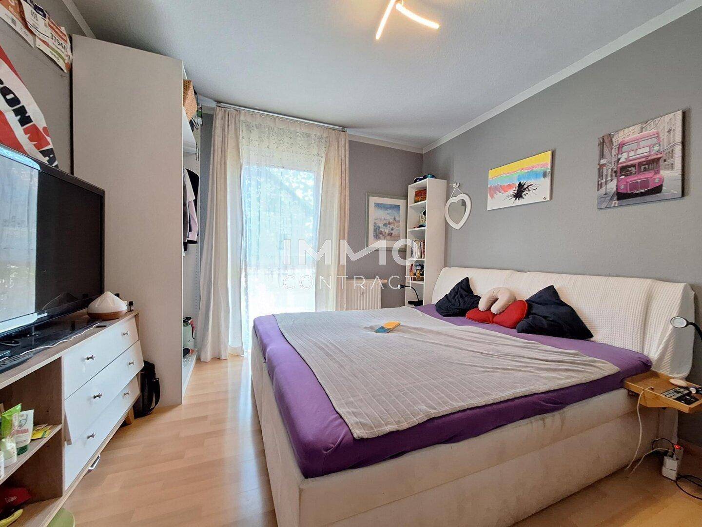 Gemütliches Schlafzimmer mit großem Bett, Kleiderschrank und Fenster für natürliches Licht.