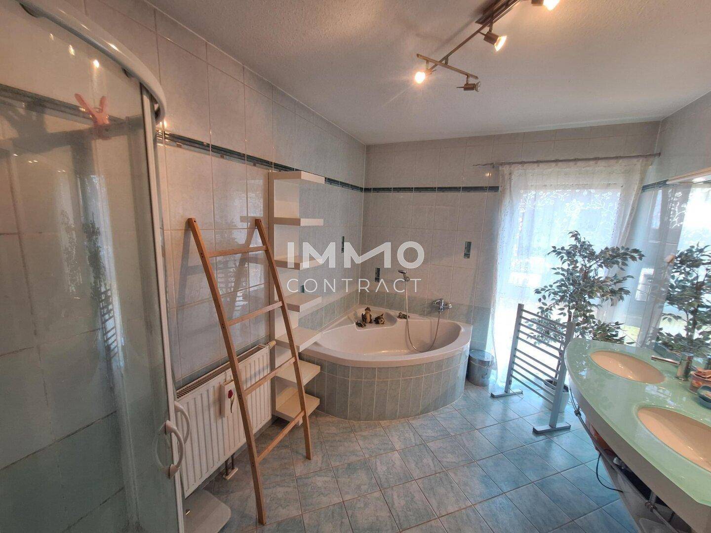 Geräumiges Badezimmer mit Eckbadewanne, Duschkabine und Doppelwaschbecken.